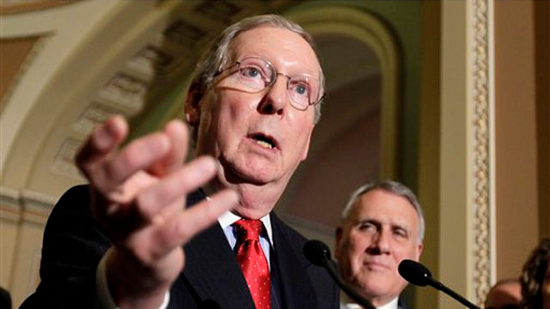 Senate Republican Leader Mitch McConnell gestures while speaking with reporters following a weekly Republican policy luncheon June 28 on Capitol Hill.