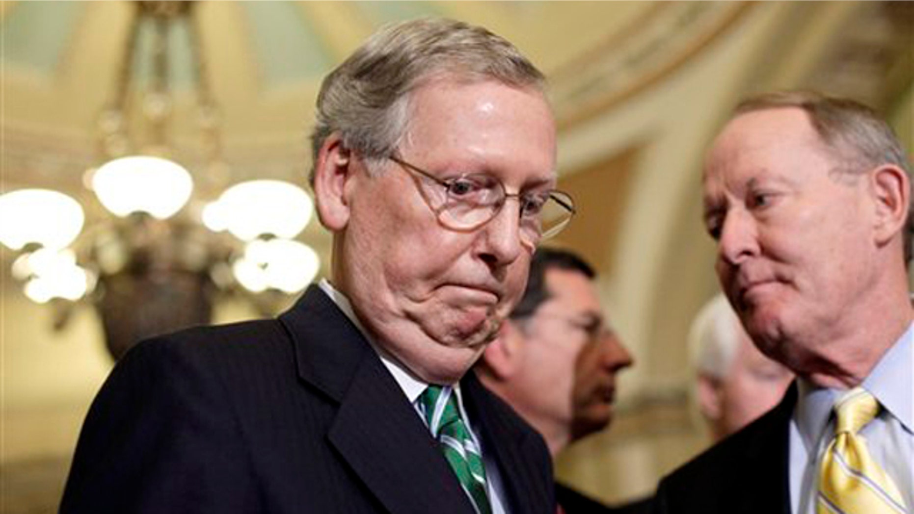 Senate Minority Leader Mitch McConnell, left, leaves a news conference on Capitol Hill in Washington Oct. 4.