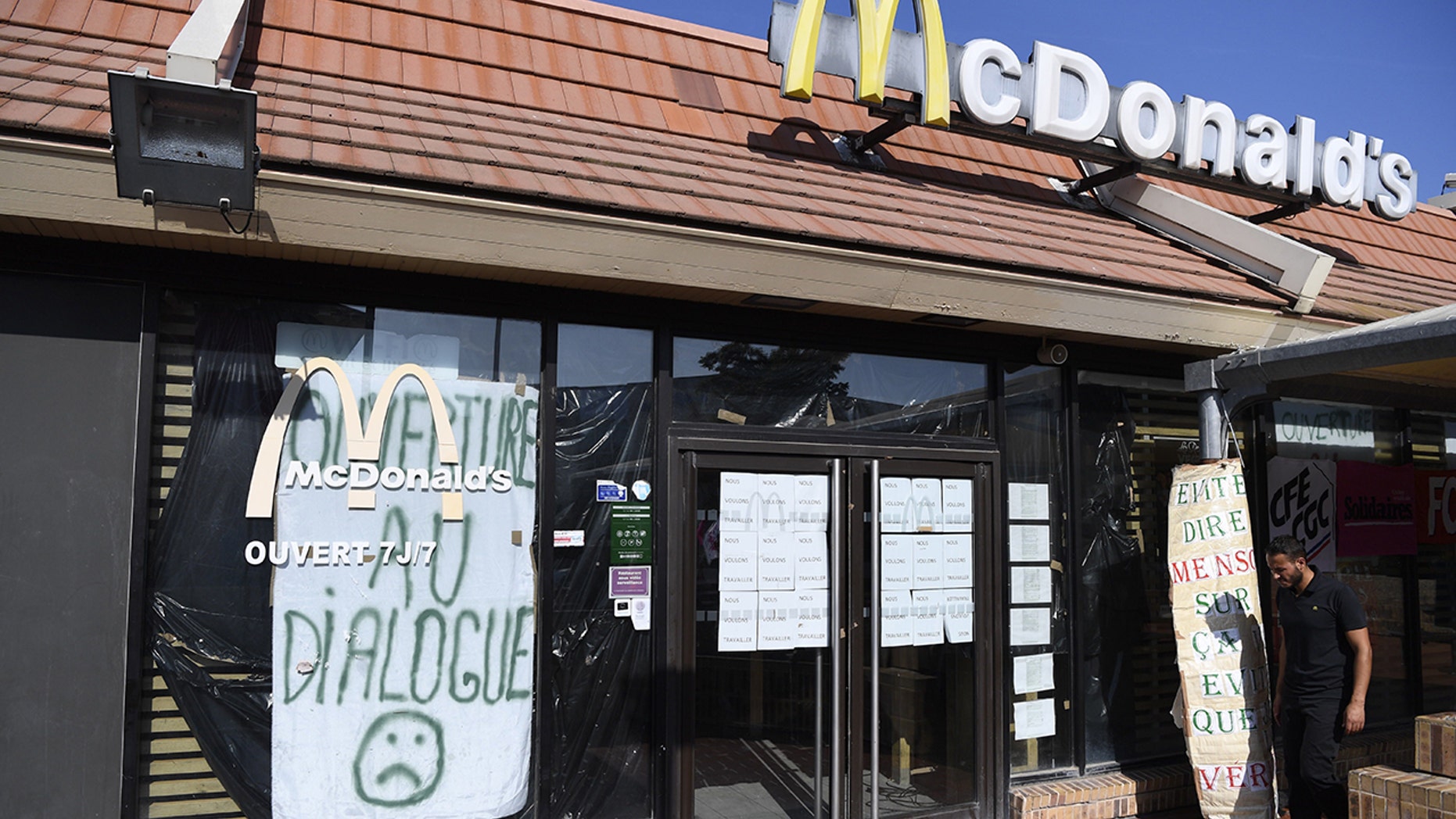 An employe of McDonald's Saint Barthelemy, on strike since the beginning of August, walks in front of the closed restaurant in the northern neighborhood of Marseille, southern France.