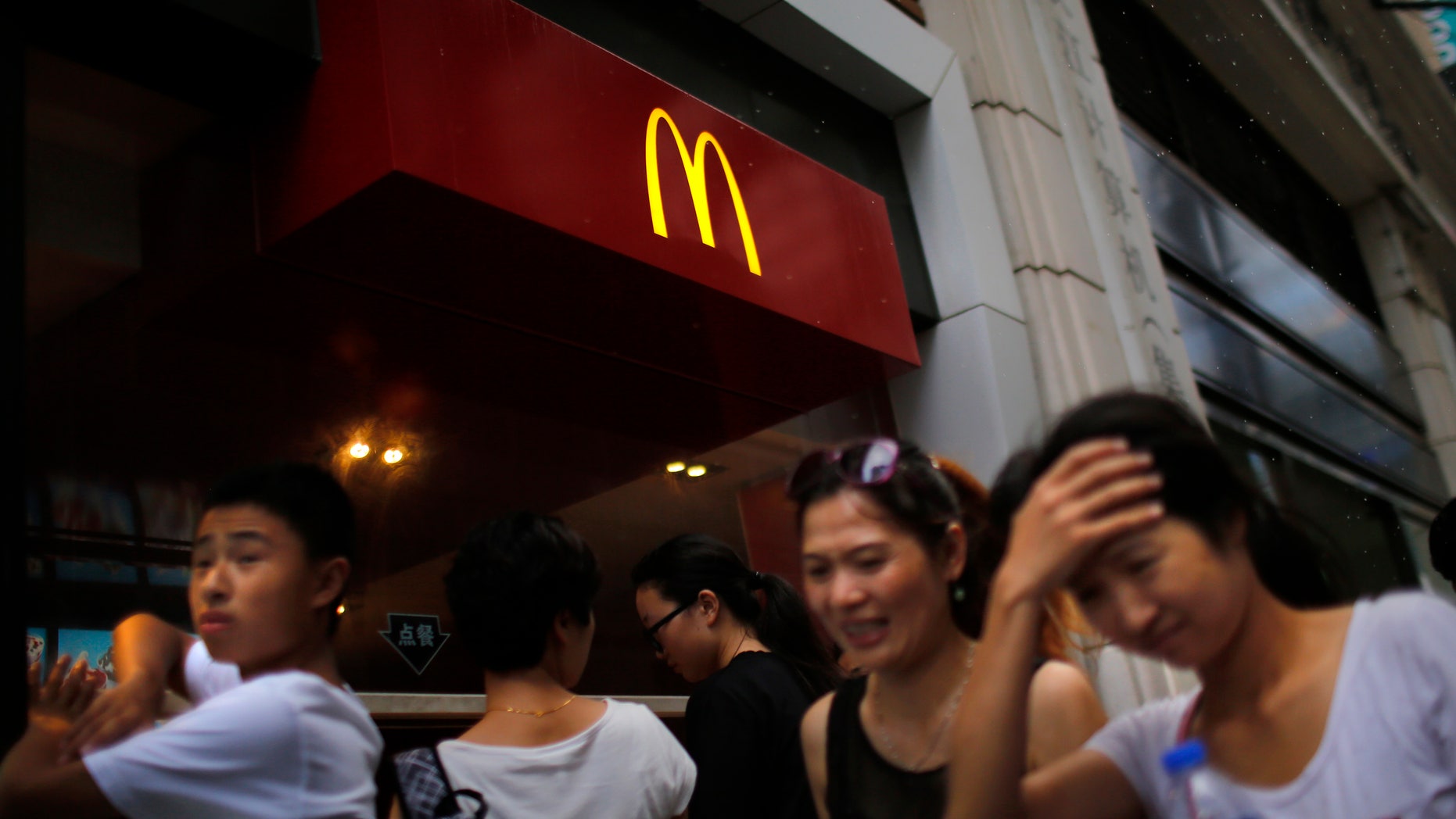 People walk by a McDonald's store in downtown Shanghai July 31, 2014. REUTERS/ Carlos Barria