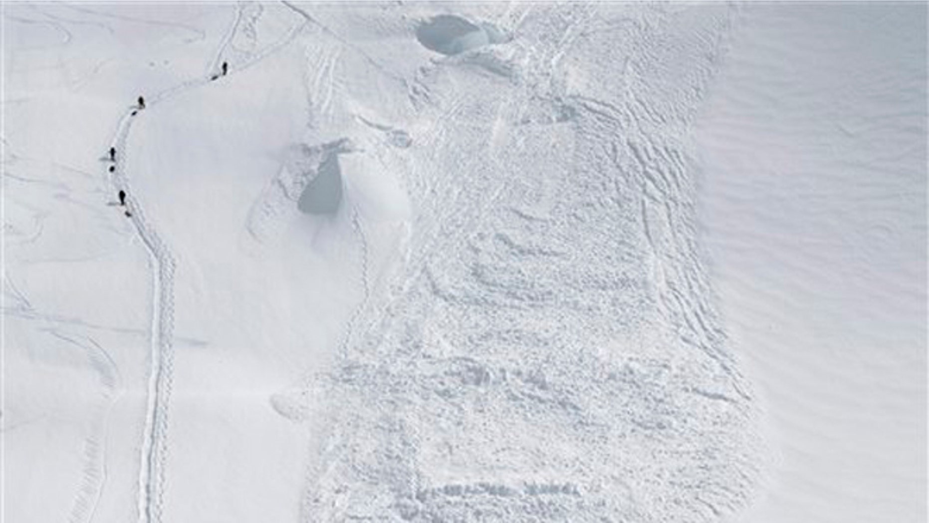 June 15, 2012: In this photo provided by the National Park Service, climbers hike through the area where an avalanche swept a Japanese climbing team off a hill during their descent from Alaska's Mount McKinley.