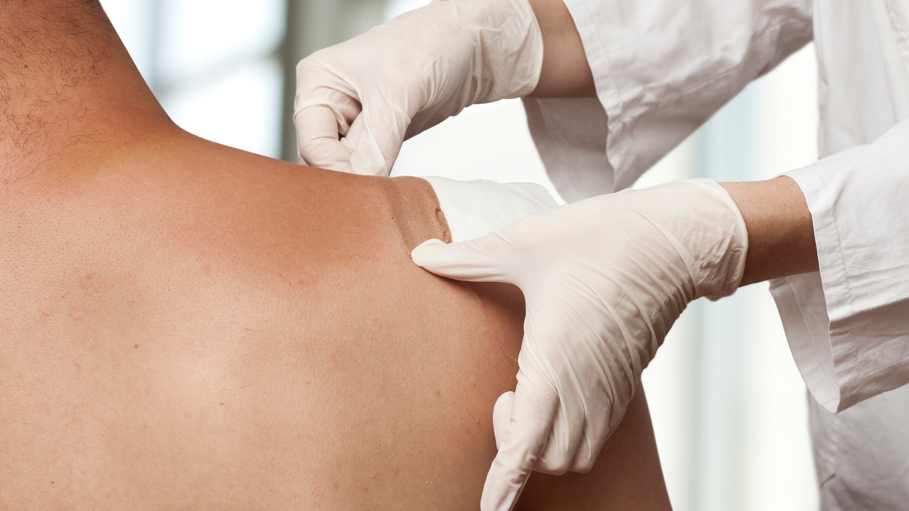 Medical assistant changes the dressing of a wound at the emergency room