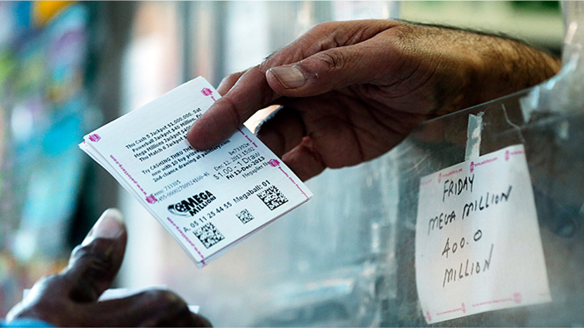 Dec. 12, 2013: A woman buys Mega Millions lottery tickets at a newsstand in Philadelphia. Mega Millions, the lesser known lottery game alongside Powerball, is stepping up to the plate with an estimated $400 million jackpot for Friday's drawing, an amount that comes less than two months after a major game revamp that is supposed to create bigger jackpots and open potential players wallets. The jackpot is the fifth largest ever in U.S. history and the second largest in Mega Millions history, trailing behind the $656 million Mega Millions jackpot in 2012. (AP/Matt Rourke)