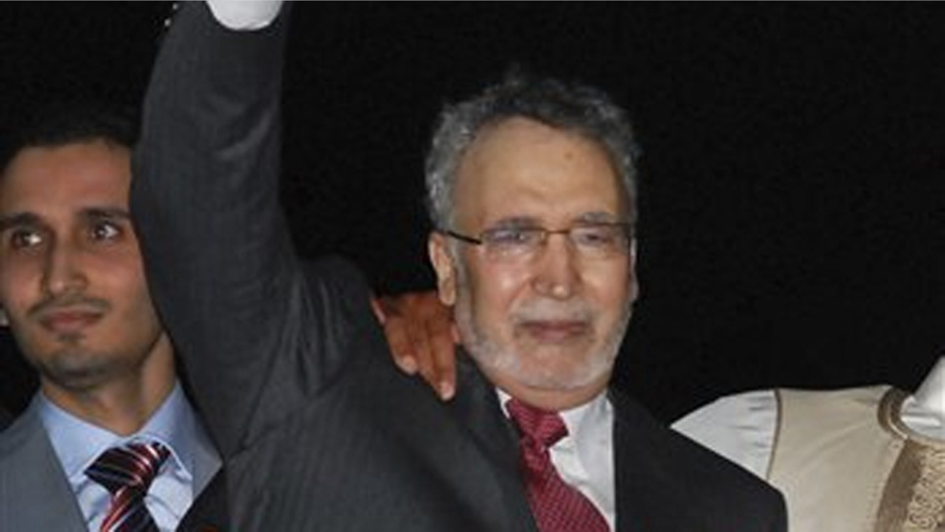 In this Aug. 20, 2009, file photo, Abdelbaset al-Megrahi gestures on his arrival at an airport in Tripoli, Libya.