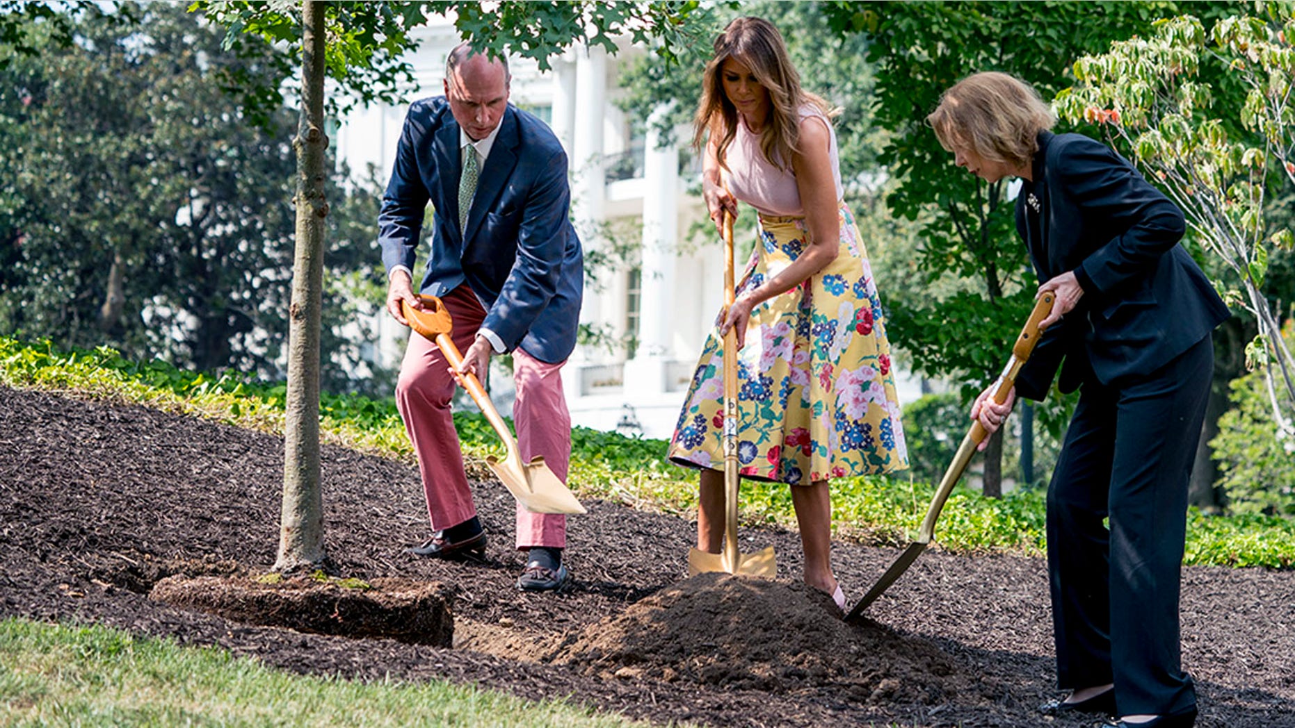 Richard Emory Gatchell, Jr., first lady Melania Trump, and Mary Jean Eisenhower participate in a presidential tree planting ceremony on the South Lawn of the White House