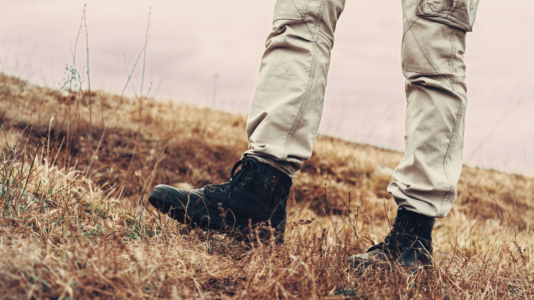 Man walking on nature in spring, view of legs