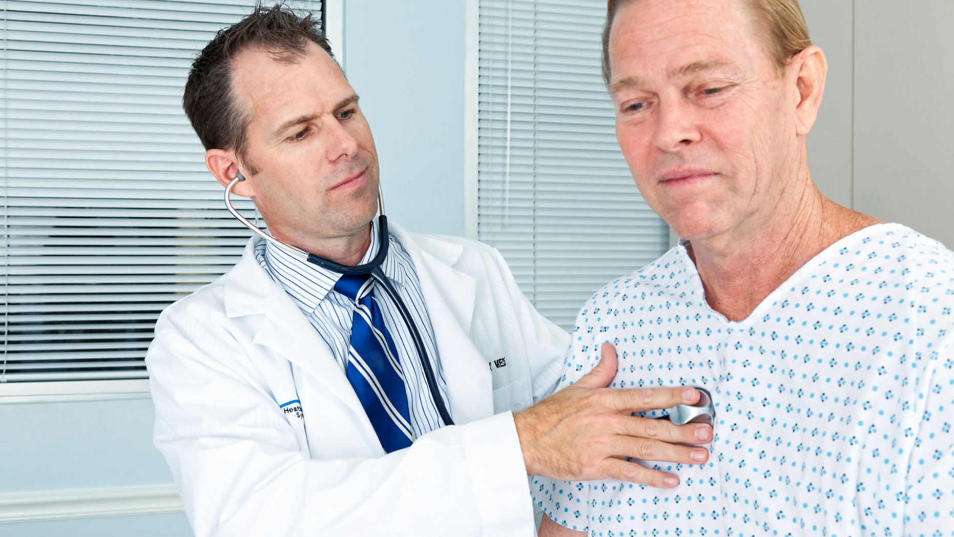 A doctor listens to a patients chest with a stethoscope.