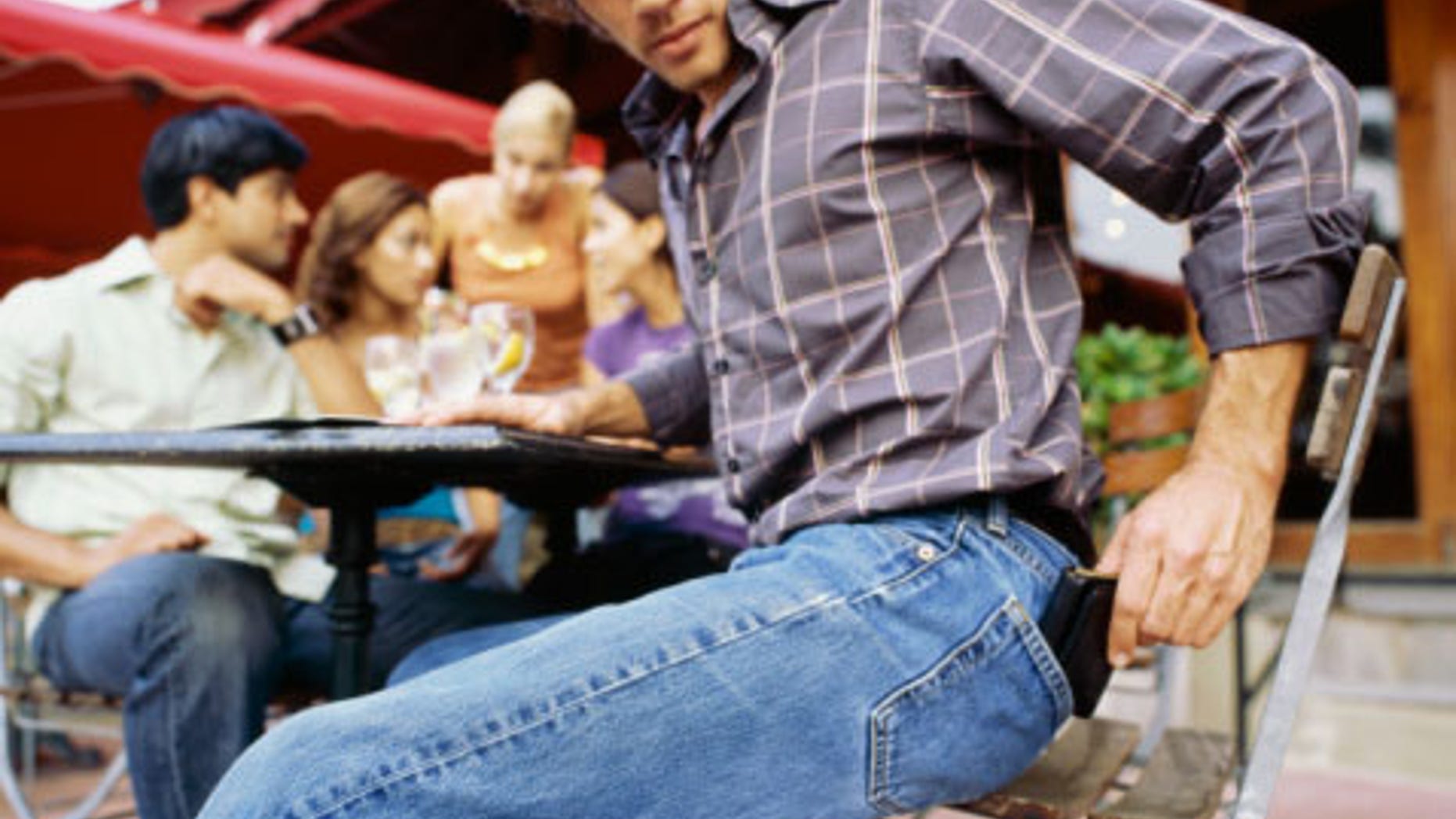 Side profile of a young man reaching for his wallet