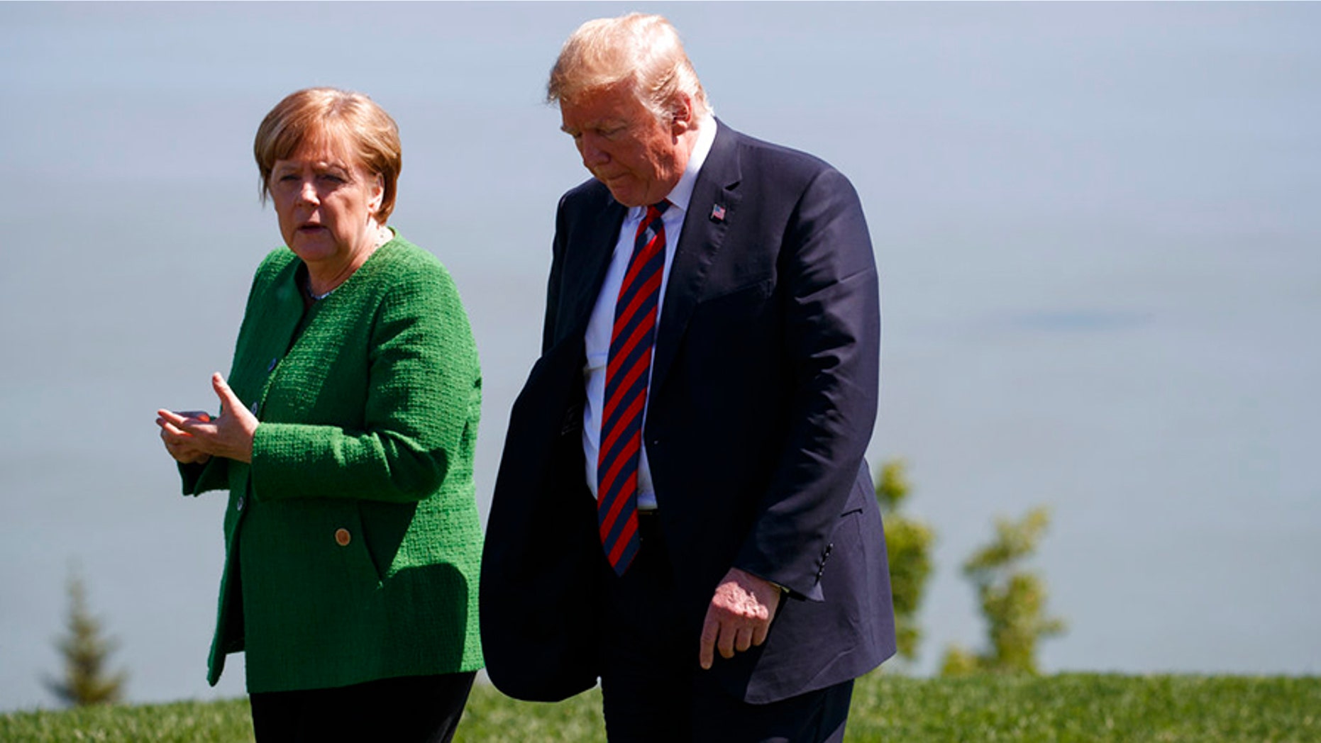 President Donald Trump, right, talks with German Chancellor Angela Merkel after the family photo during the G7 Summit, Friday, June 8, 2018, in Charlevoix, Canada. (AP Photo/Evan Vucci)
