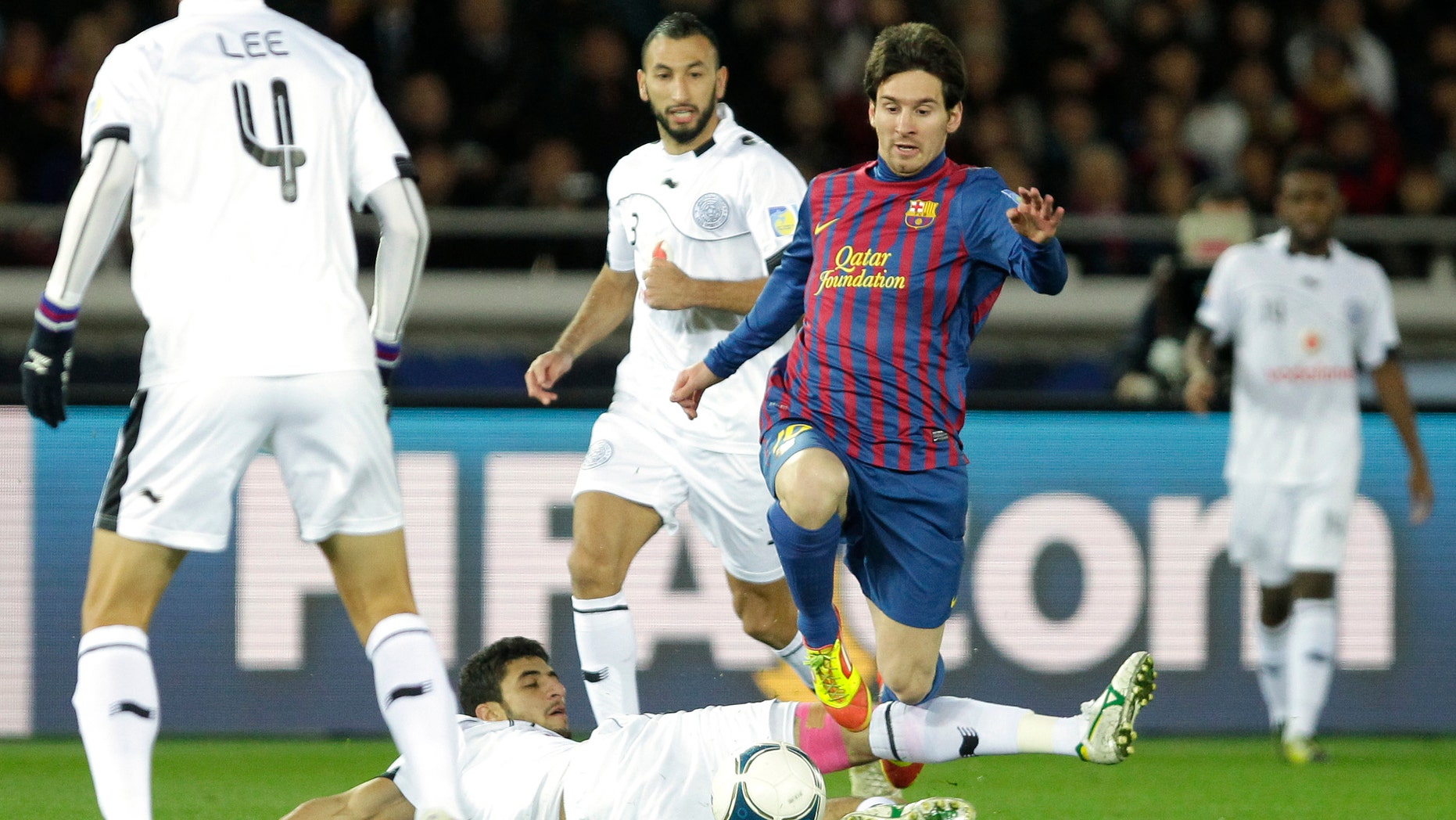 Spain's FC Barcelona midfielder Lionel Messi avoids a tackle by Qatar's Al-Sadd Sports Club defender Ibrahim Abdulmajed during their semifinal match of the Club World Cup soccer tournament in Yokohama, near Tokyo, Thursday, Dec. 15, 2011. (AP Photo/Shizuo Kambayashi)