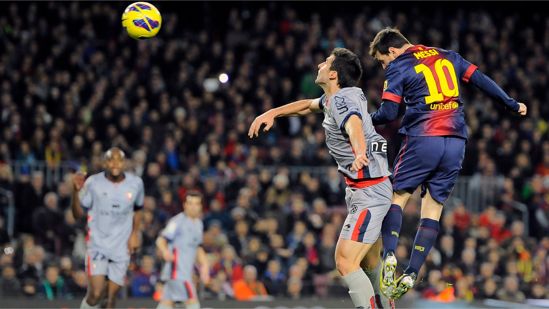 Barcelona's Lionel Messi, from Argentina, right, vies for the ball with Osasuna's Marc Bertran during their Spanish League soccer match at Camp Nou stadium in Barcelona, Spain, Sunday, Jan. 27, 2013. Barcelona won the match 5-1. (AP Photo/Alvaro Barrientos)