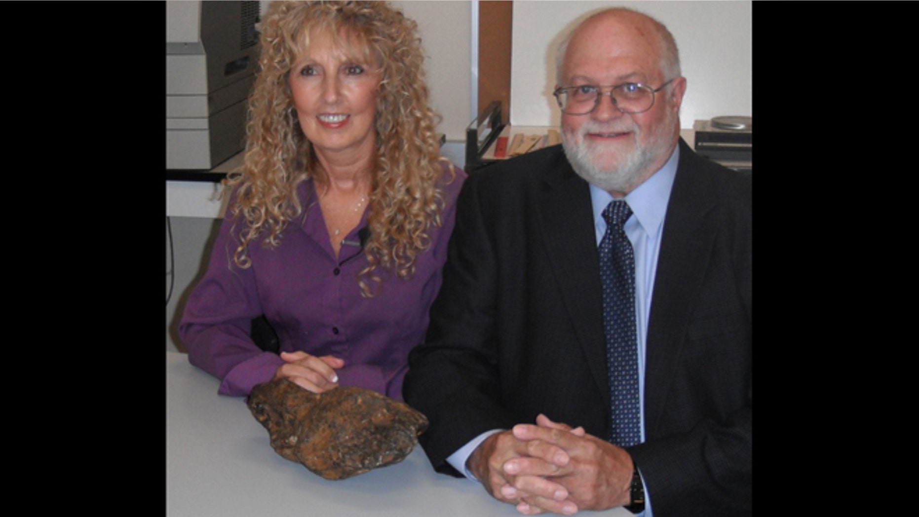 Donna Lewis, left, with Dr. Jerry Cook and the meteorite.