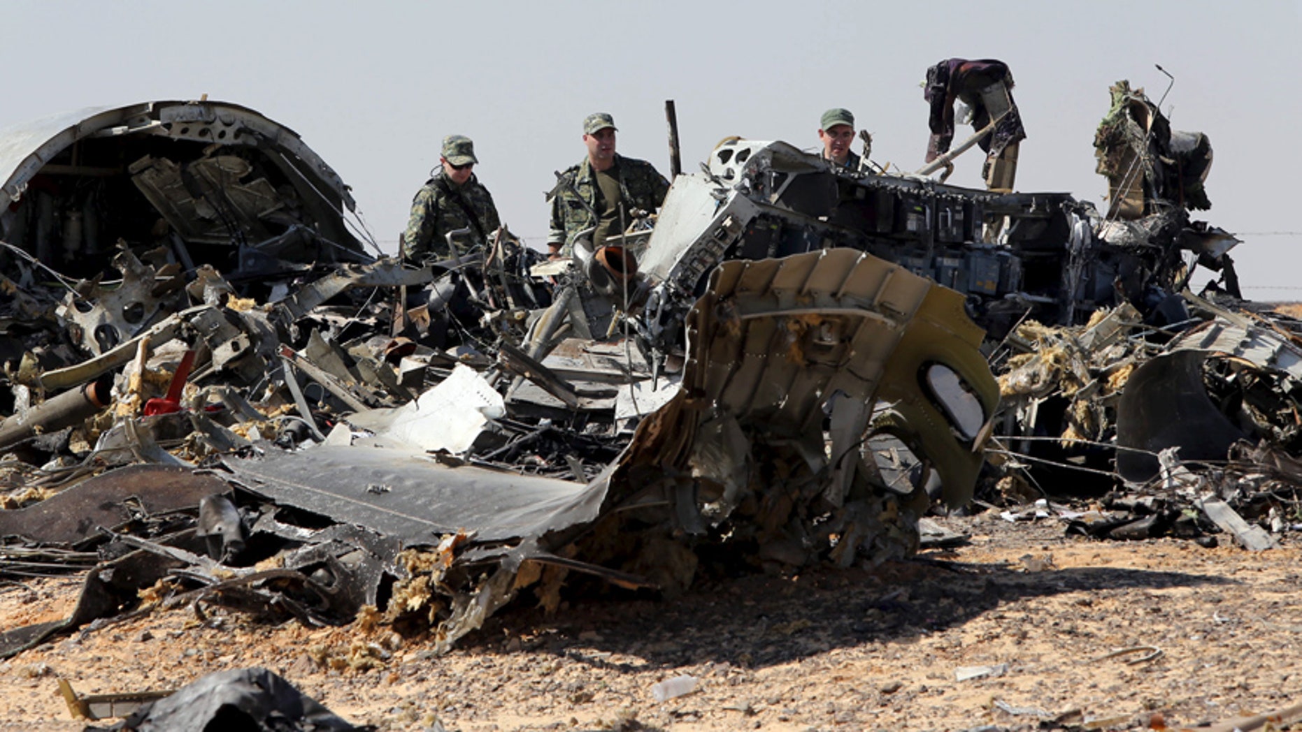 Nov. 1, 2015: Military investigators from Russia stand near the debris of a Russian airliner at the site of its crash at the Hassana area in Arish city, northern Egypt.