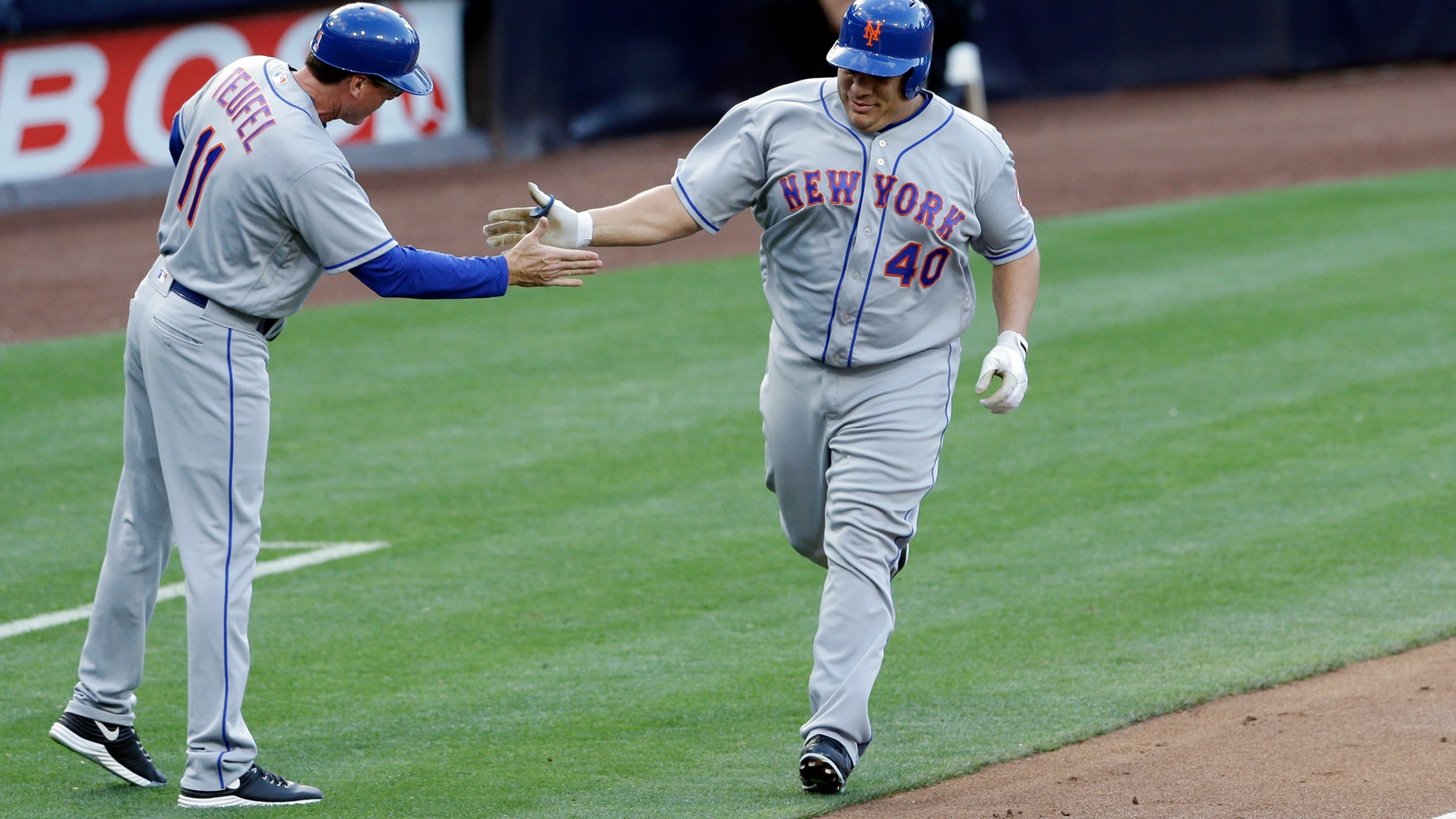 Bartolo Colon is greeted by third base coach Tim Teufel after hitting his first career home run.
