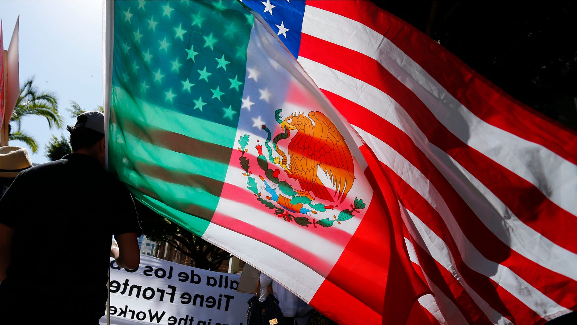 May 1, 2013: A youth carries national flags of the U.S. and Mexico through the streets of San Diego, during a demonstration about workers rights and immigration reform.