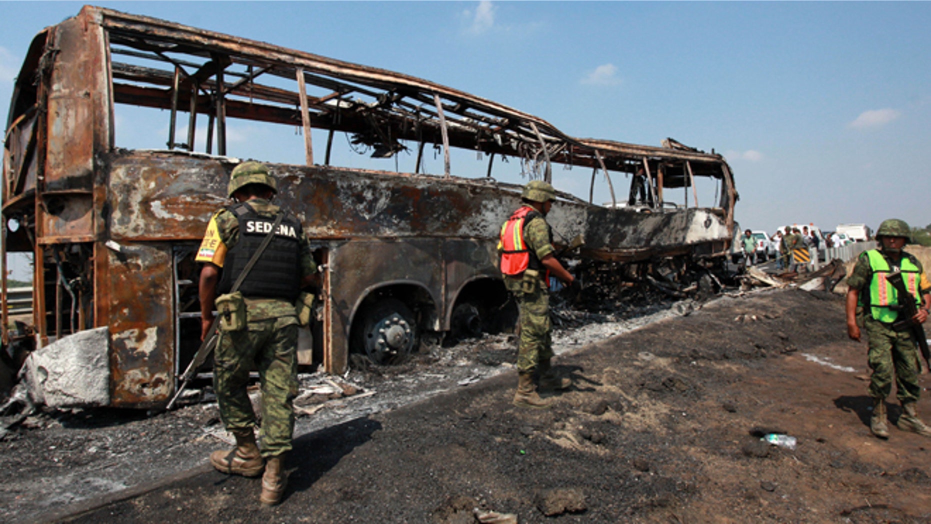 April 13, 2014: Soldiers guard the site where a passenger bus slammed into a broken-down truck and burst into flames near the town of Ciudad Isla in the Gulf state of Veracruz, Mexico. Dozens of people traveling on the bus to Mexico City burned to death inside the bus.