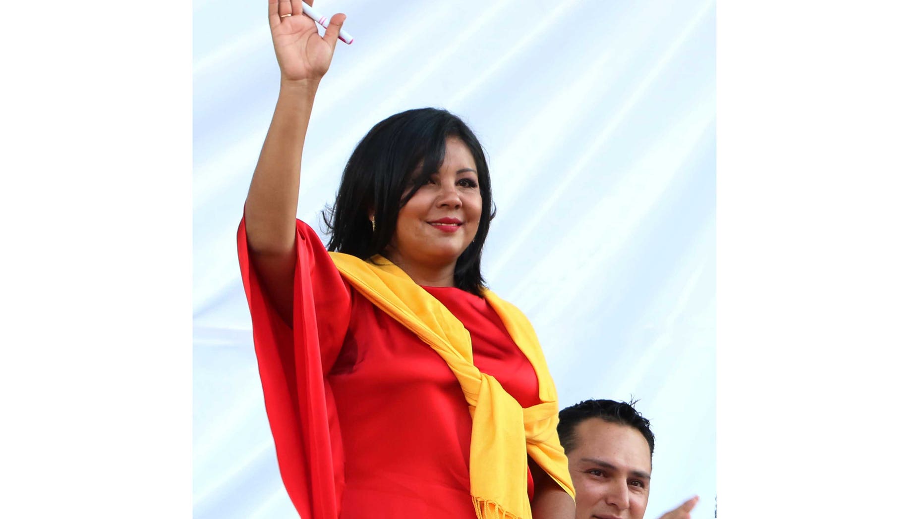 In this Friday, Jan. 1, 2016 photo, Gisela Mota waves during her swearing in ceremony as mayor of Temixco, Morelos State, Mexico. The Morelos state Public Security Commission says attackers invaded Mota's house on Saturday morning and killed her. (AP Photo/Tony Rivera)