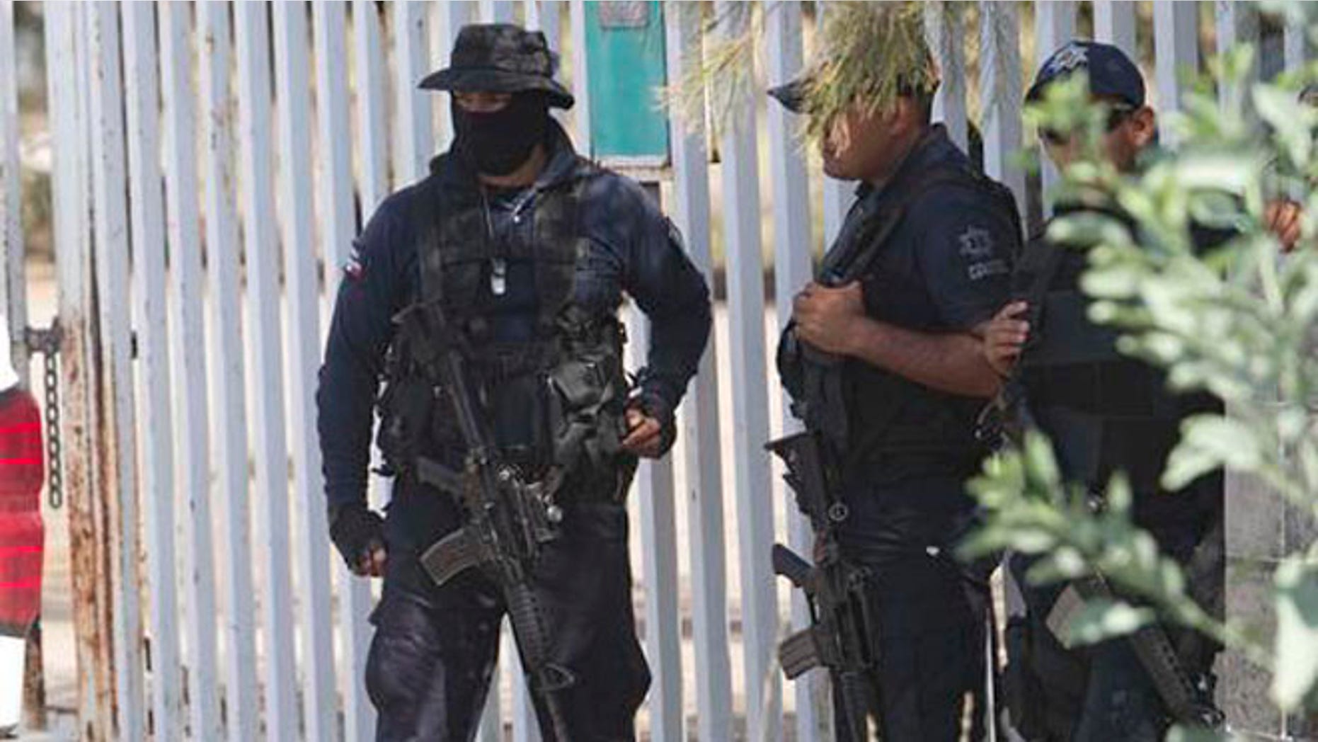 FILE - In this May 22, 2015, file photo, Mexican state police stand guard near the entrance of Rancho del Sol, where a shootout with the authorities and suspected criminals happened near Vista Hermosa, Mexico. Mexico's National Human Rights Commission said on Thursday, Aug. 18, 2016, that it has concluded that 22 people were arbitrarily executed by federal police during the event. Commission President Luis Raul Gonzalez Perez said their investigation revealed a range of human rights abuses on the part of government forces. (AP Photo/Refugio Ruiz, File)