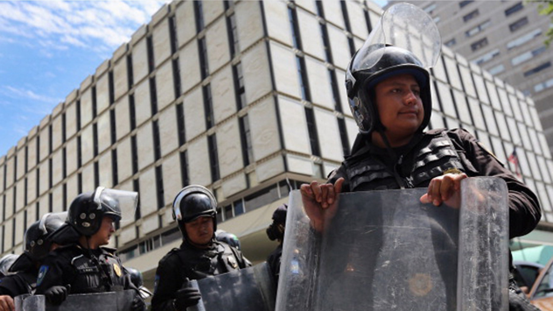 MEXICO CITY, MEXICO - JUNE 26: Mexican police stand guard outside the U.S. emabassy as a group of protesters passes by on June 26, 2012 in Mexico City, Mexico. Students have been protesting throughout the city calling for transparency and fairness as Mexicans go to the polls to elect a new president this Sunday, July 1. (Photo by John Moore/Getty Images)