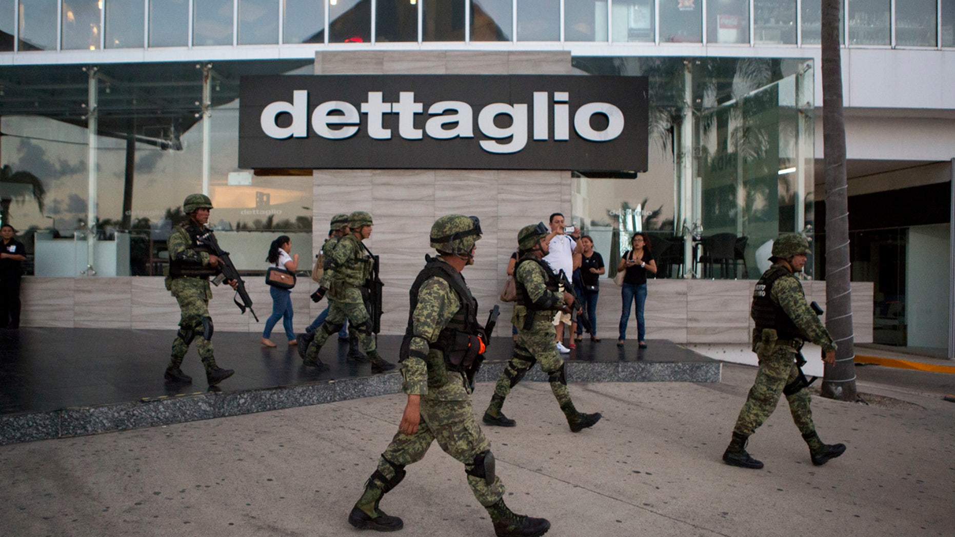 Soldiers walk outside Plaza Las Americas mall following reports of gunfire in Cancun, Mexico, Tuesday, Jan. 17, 2017.