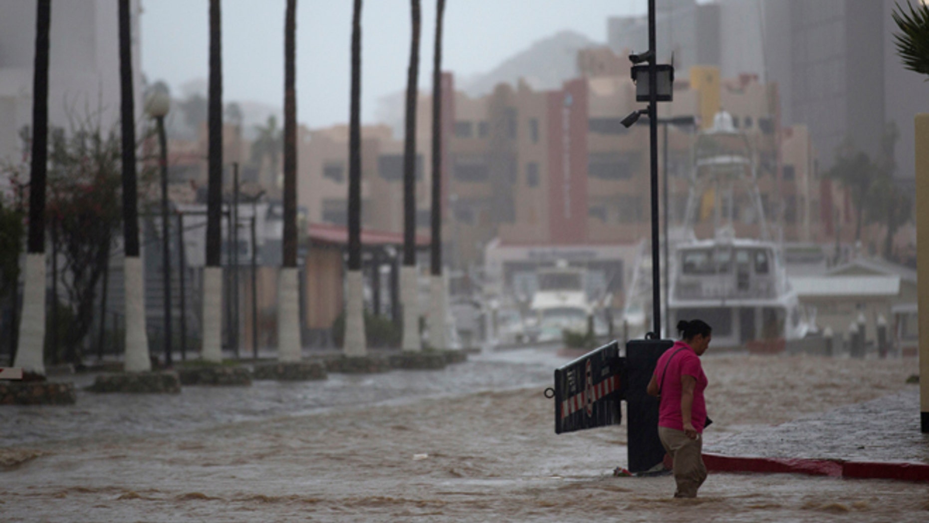 A woman wades through a street flooded by the heavy rains brought on by Hurricane Newton in Cabo San Lucas, Mexico, Tuesday, Sept. 6, 2016.