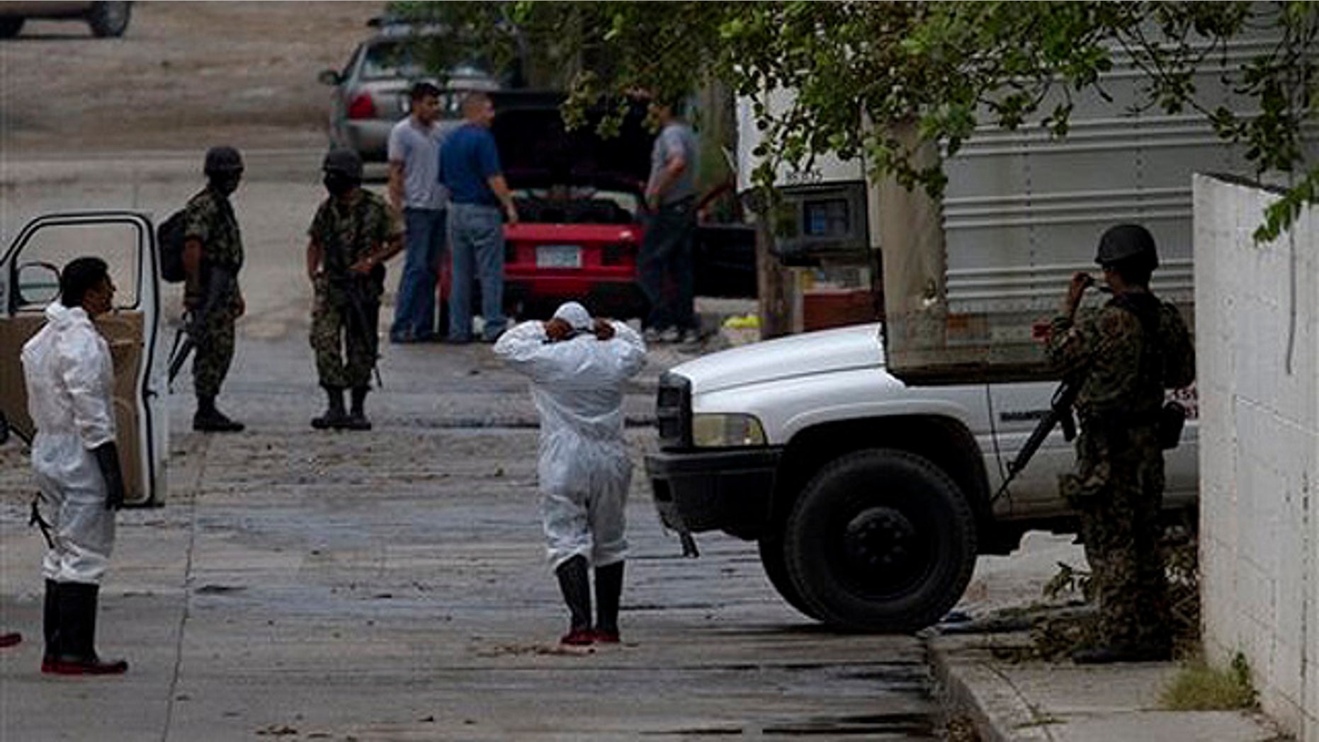 Aug. 23: Mortuary worker wearing protective suits and Mexican marines are seen outside a funeral home where the bodies of 72 men and women that were allegedly killed by the Zetas drug gang are kept in San Fernando, just 100 miles from the Mexican border with the U.S. near the city of Matamoros, Mexico.