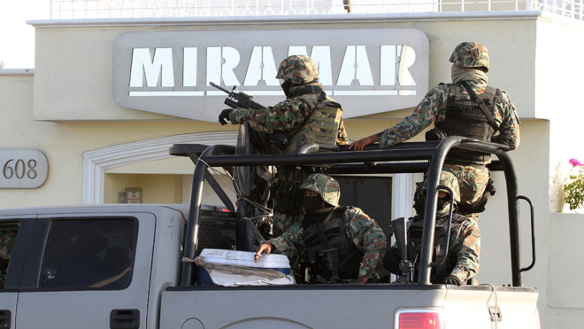Feb. 22, 2014: Military personnel stand atop a truck during a raid in Mazatlan, Mexico.