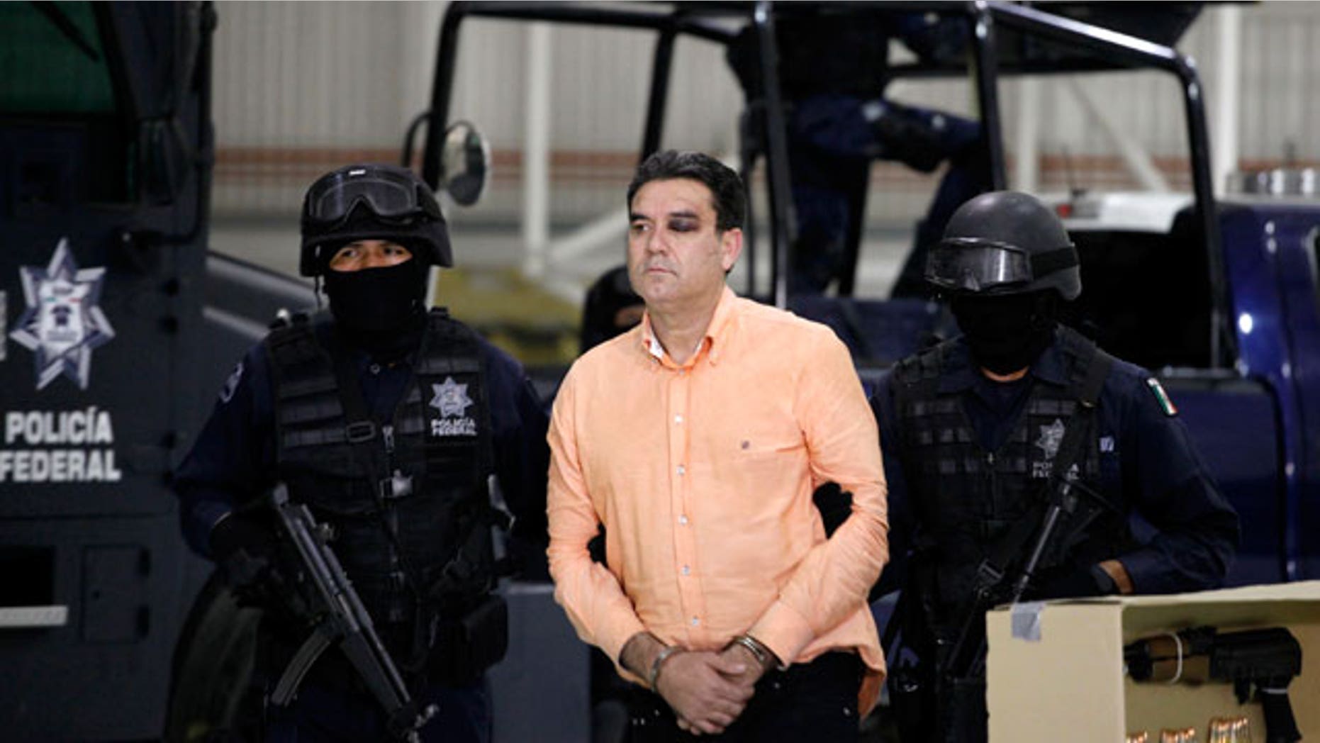 Police officers escort suspected drug trafficker Manuel Fernandez as he is presented to the media at the federal police headquarters in Mexico City, Monday Nov. 8, 2010. According to federal police Fernandez, an alleged member of the criminal organization led by Joaquin Guzman Loera, aka "El Chapo Guzman", was arrested Sunday in the northern city of Culiacan, Sinaloa state.
