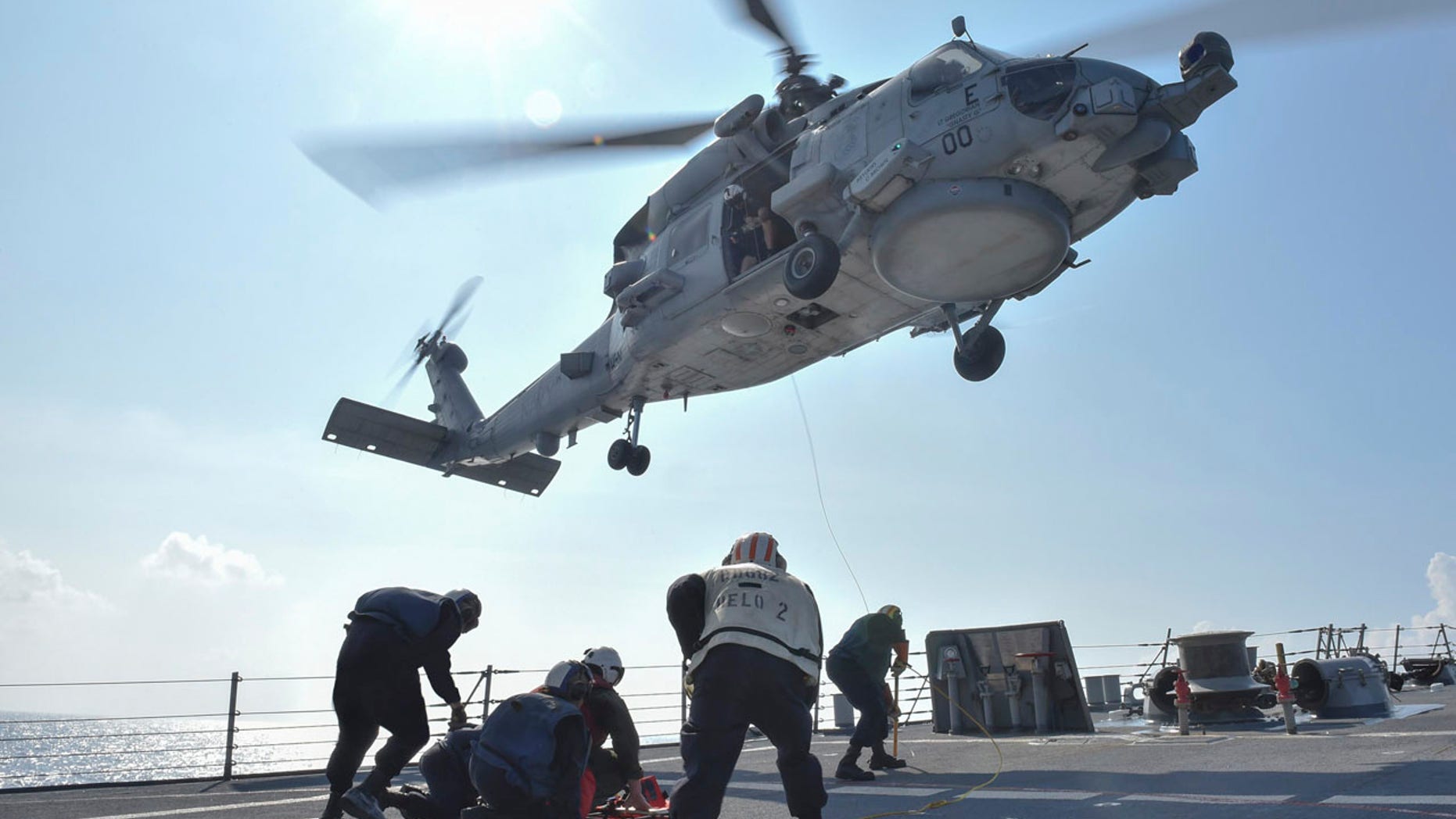 U.S. Navy Sailors participate in a medical training exercise on the deck of the Arleigh Burke-class guided missile destroyer USS Lassen (DDG 82) with an MH-60R Seahawk helicopter, in the South China Sea, October 28, 2015, provided by the U.S. Navy.