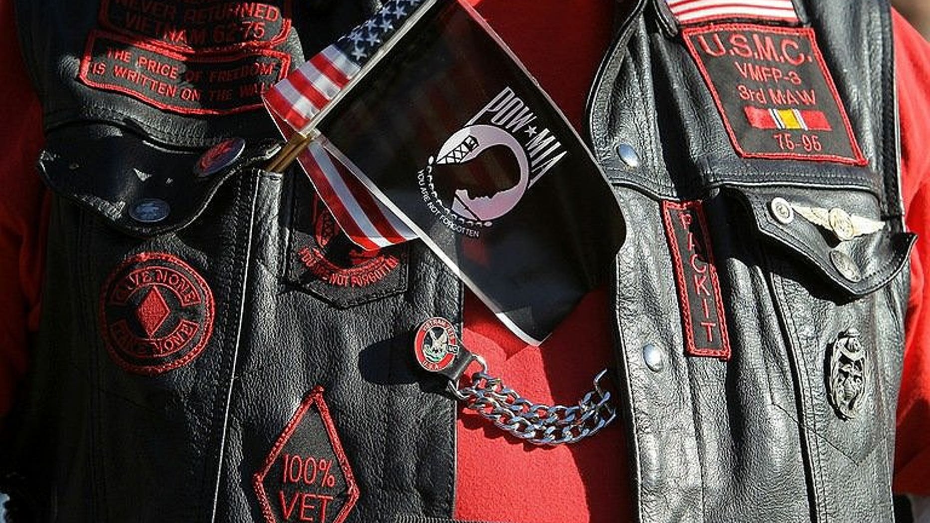 A veteran wears a US and POW-MIA flag together on his vest
