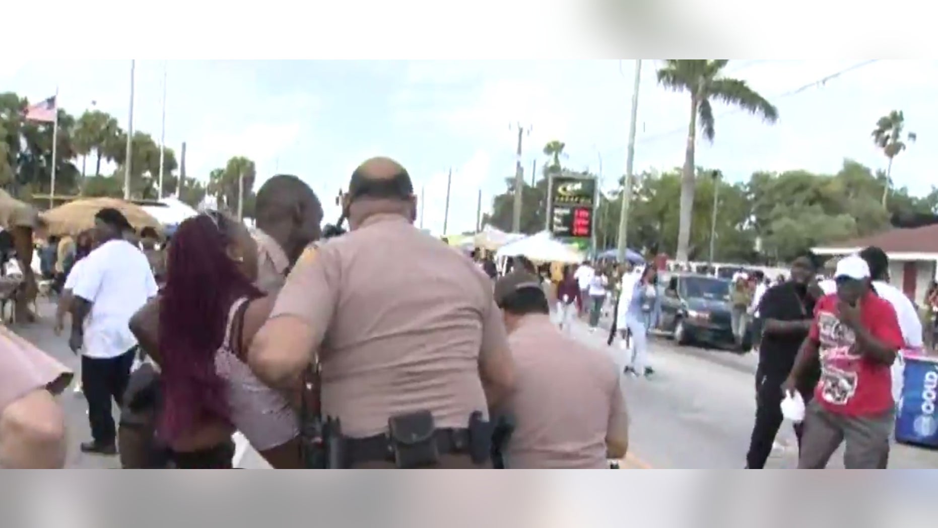 Police carrying away a woman who appeared to be hurt.