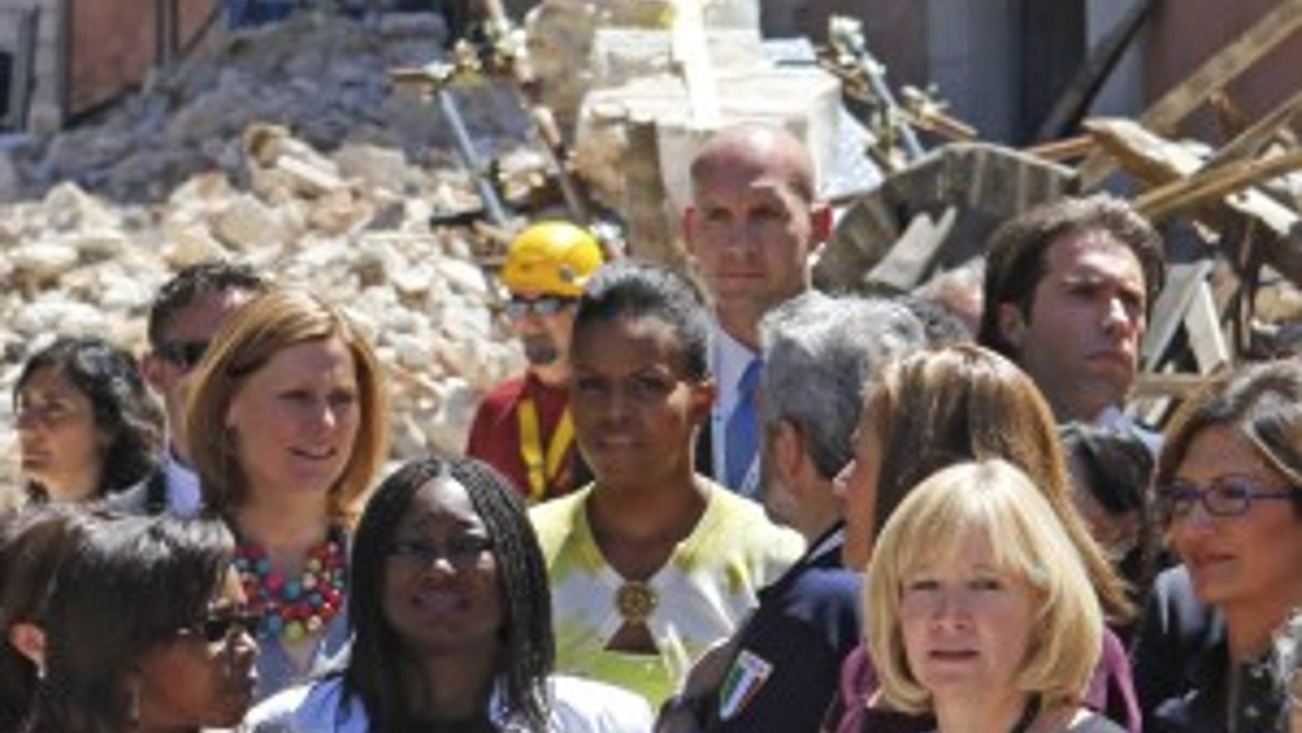 First lady Michelle Obama, center, tours earthquake damage with Sarah Brown, wife of British Prime Minister Gordon Brown, second from top left, Juliana Olabintan Nwanze, wife of International Fund for Agricultural Development (IFAD) president Kanayo Nwanze, second from bottom left, Laureen Harper, wife of Canadian Prime Minister Stephen Harper, second from right foreground, and others on the sidelines of the G8 Summit in L'Aquila, Italy, Thursday, July 9, 2009. (AP Photo/Charles Dharapak)