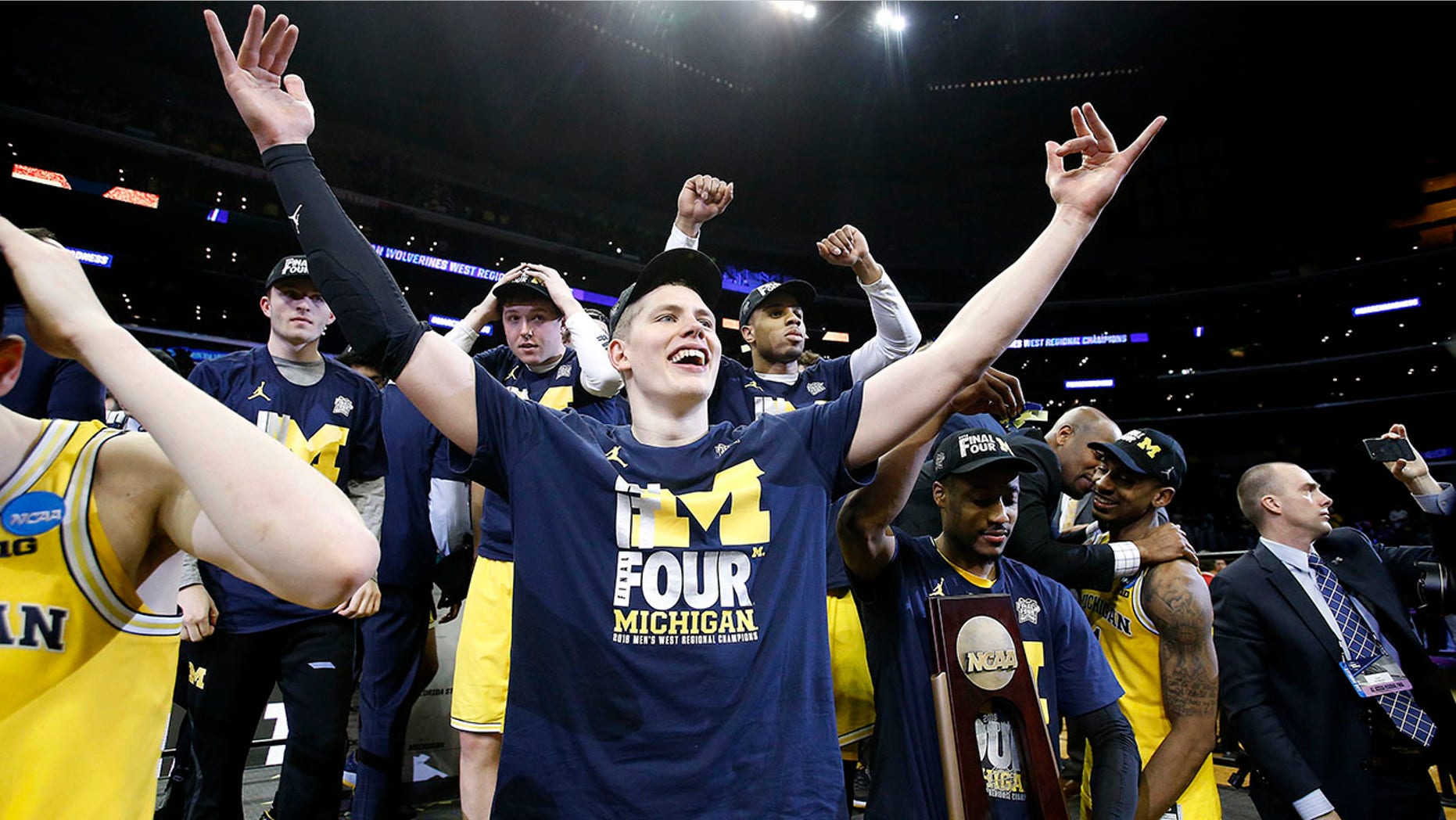 Michigan forward Moritz Wagner, foreground, and teammates celebrate after defeating Florida State 58-54 in an NCAA men's college basketball tournament regional final, in Los Angeles, March 24, 2018.