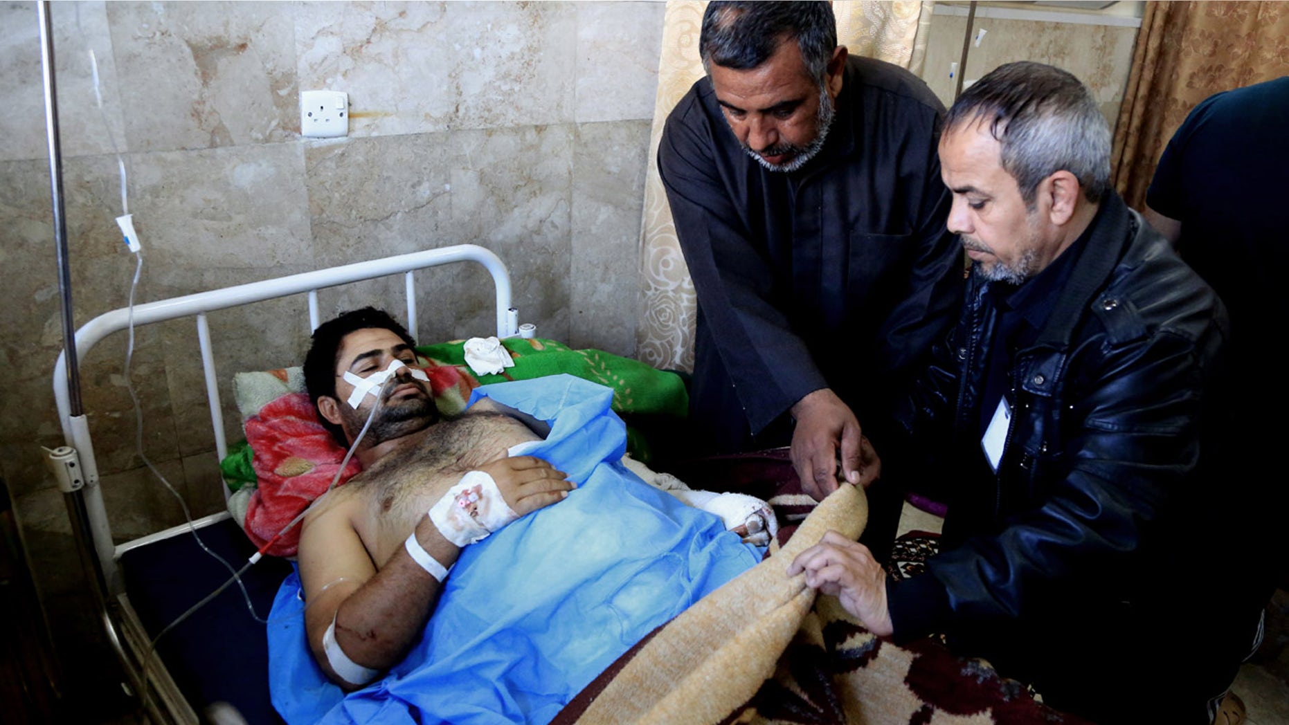 Feb. 29, 2016: An injured victim of bombing attacks receives treatment at the Imam Ali Hospital in Sadr City, Baghdad, Iraq. (AP Photo/Karim Kadim)