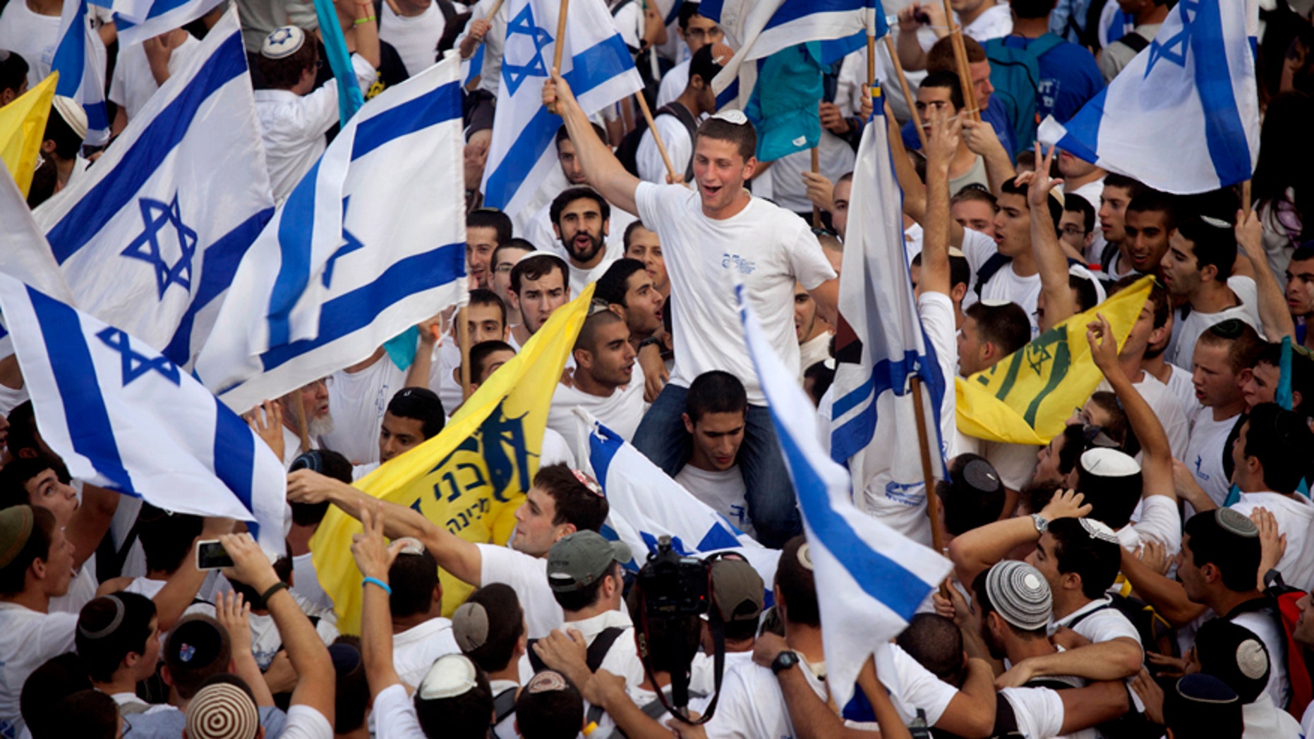 Israelis wave national flags during Jerusalem Day celebrations in Jerusalem, Wednesday, May 28,2014.