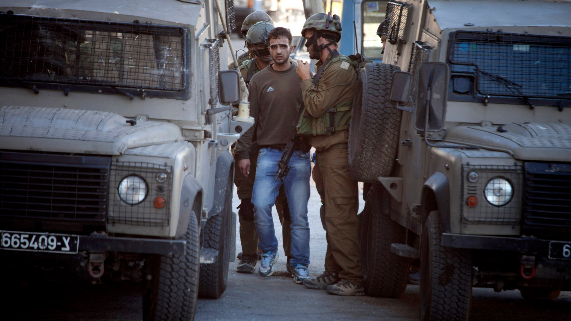 June 14, 2014: Israeli soldiers arrest a Palestinian man in the West Bank City of Hebron.