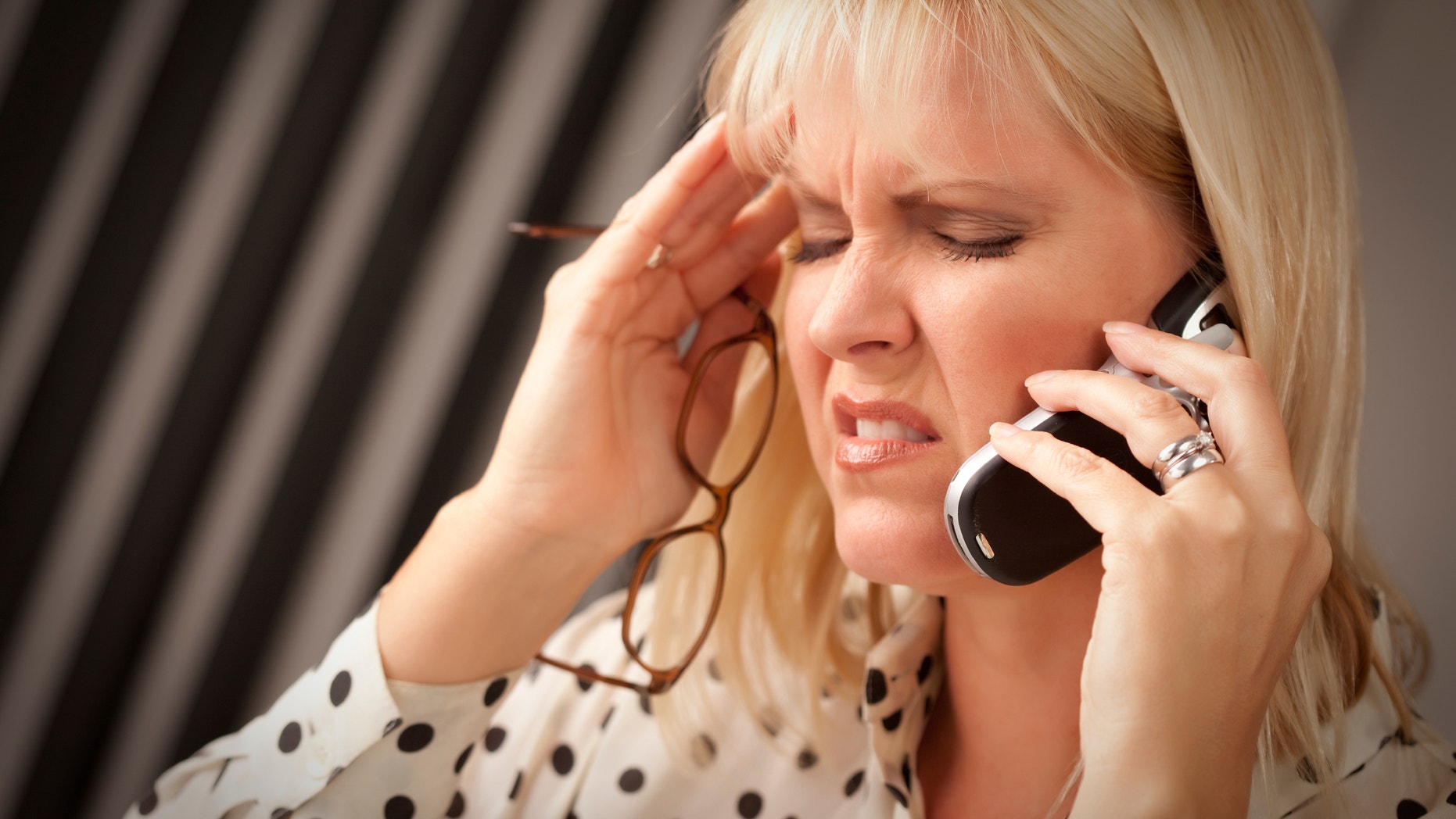 Blonde Woman on Her Cell Phone with Stressed Look on Her Face.