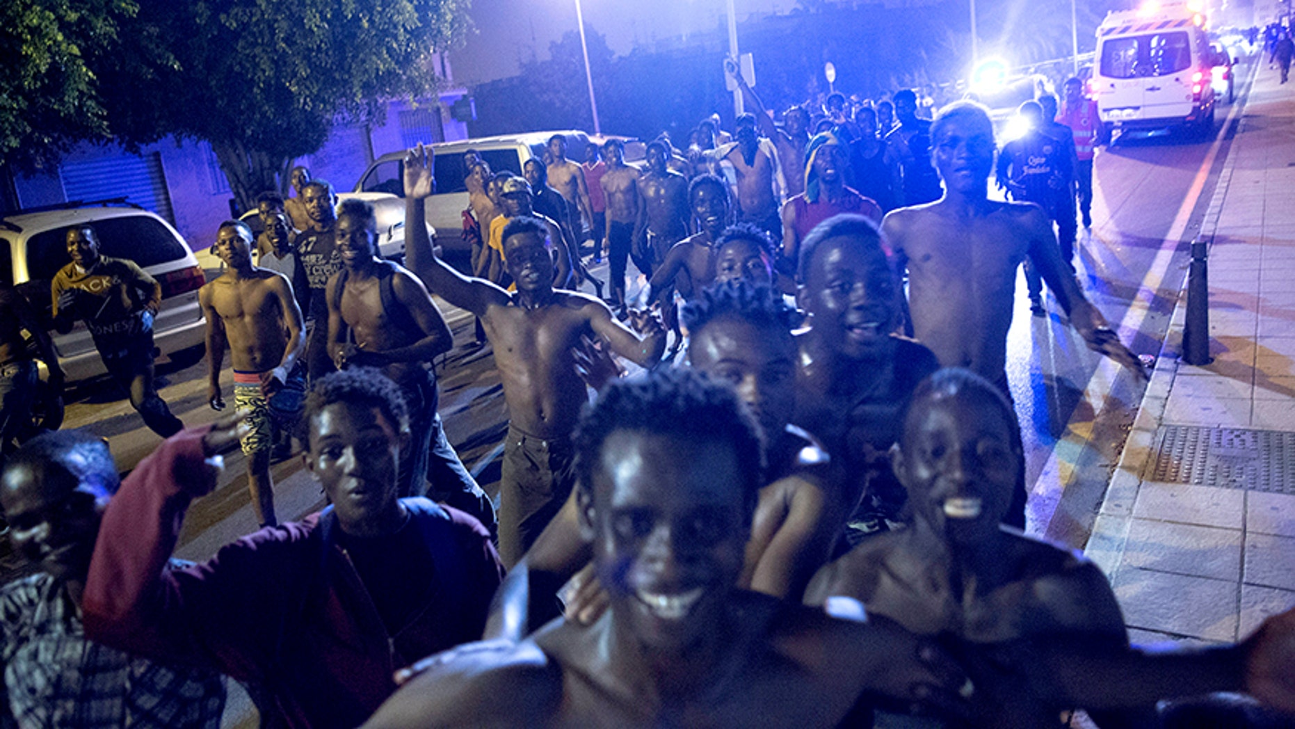 African migrants react after crossing the border from Morocco to Spain's North African enclave of Ceuta.