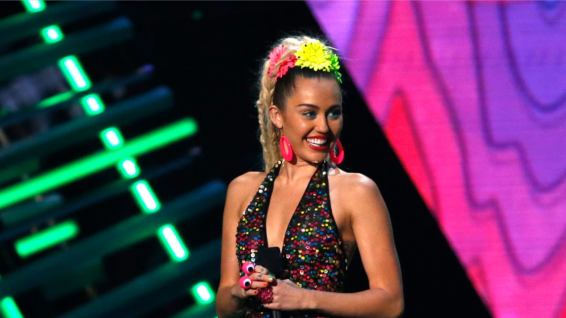August 30, 2015. Show host Miley Cyrus speaks on stage at the 2015 MTV Video Music Awards in Los Angeles, California.