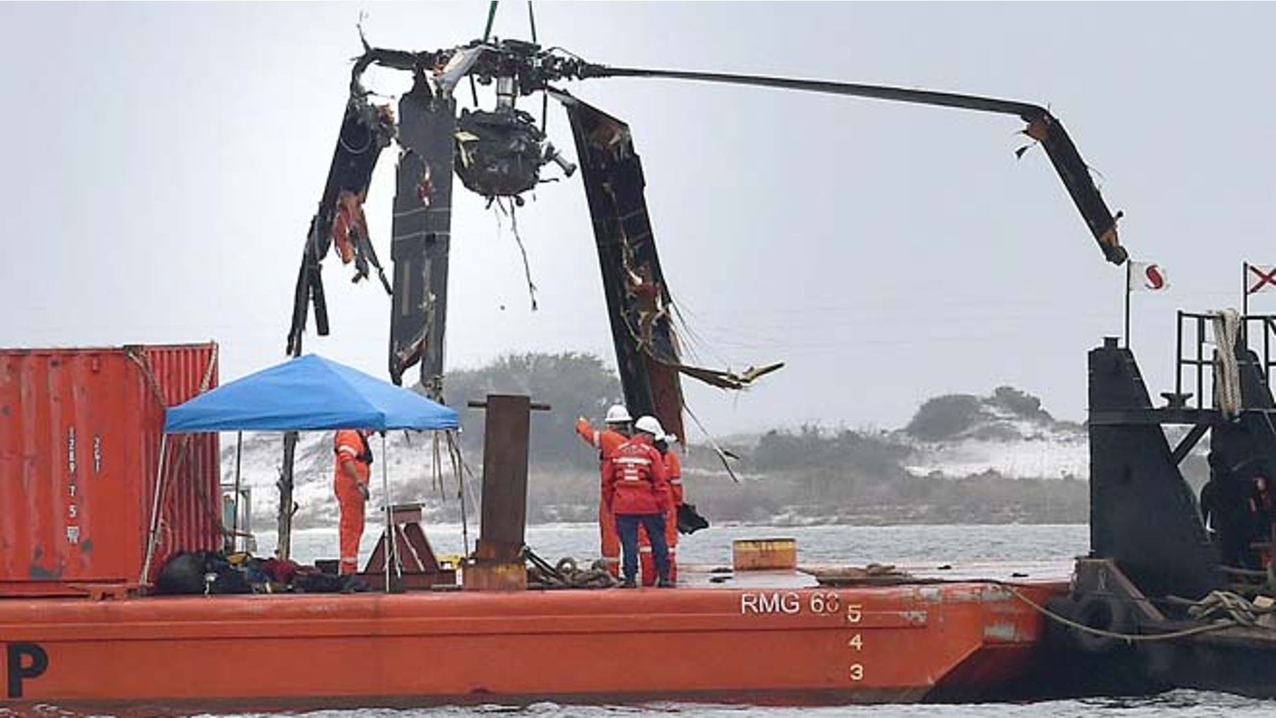 March 13, 2015: Crews lower a piece of a Black Hawk helicopter onto a barge in the Santa Rosa Sound near Pritchard Point in Navarre, Fla. (AP/Northwest Florida Daily News, Nick Tomecek)