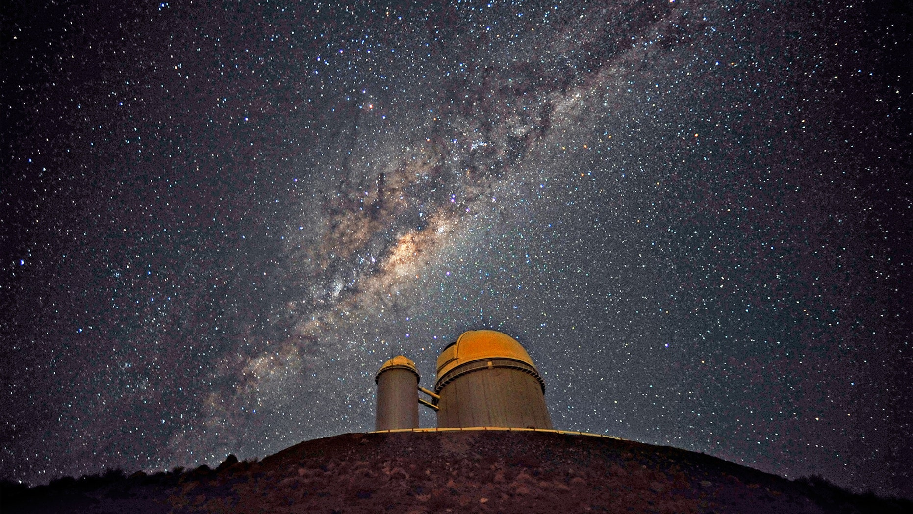 The Milky Way stretches across the sky above the La Silla telescope in Chile. Trillions of planets lurk in our galaxy, many of which have not yet been found.