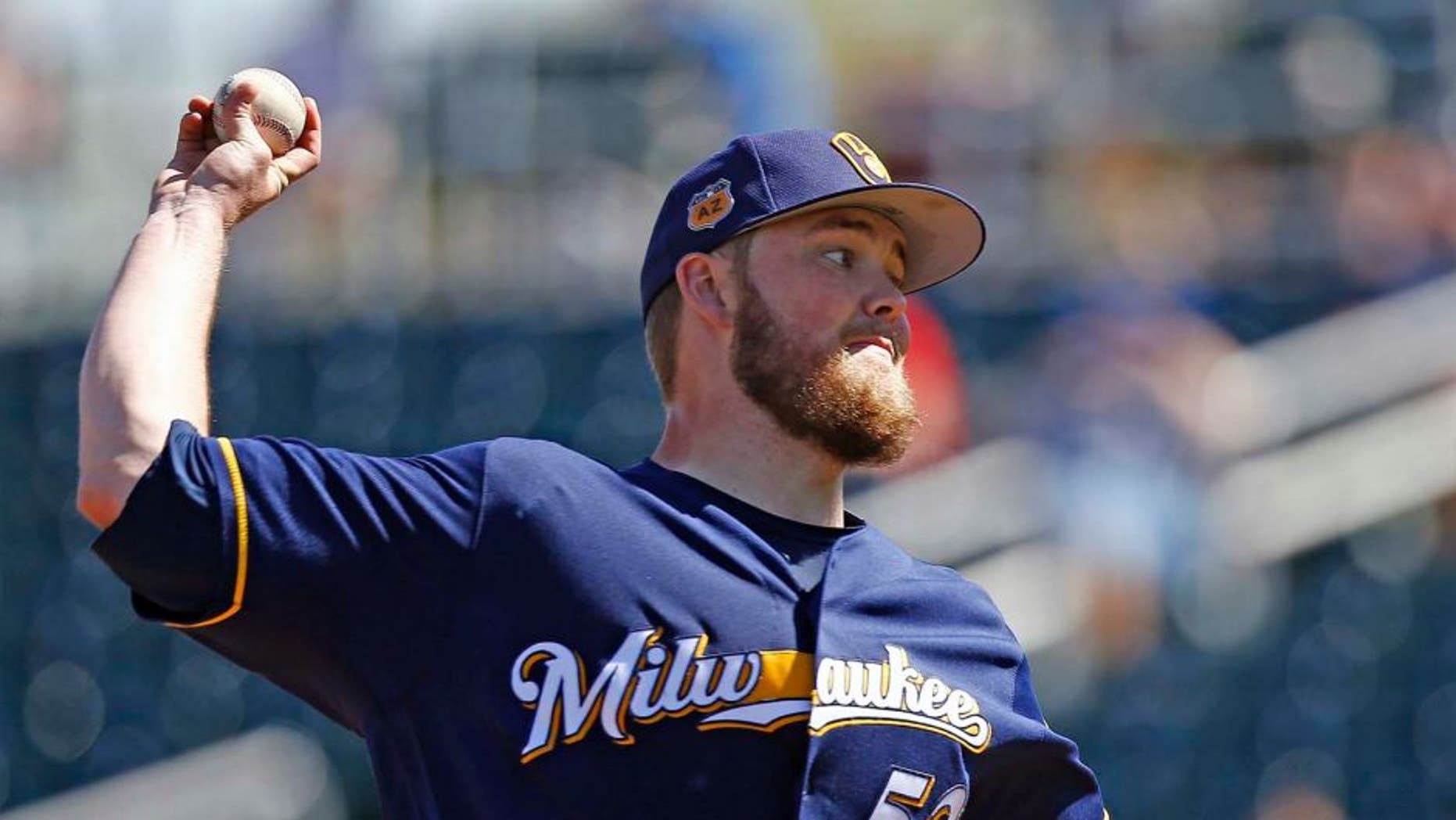 Milwaukee Brewers starting pitcher Jimmy Nelson throws against the Cincinnati Reds during the first inning of a spring training baseball game Sunday, March 12, 2017, in Goodyear, Ariz. (AP Photo/Ross D. Franklin)