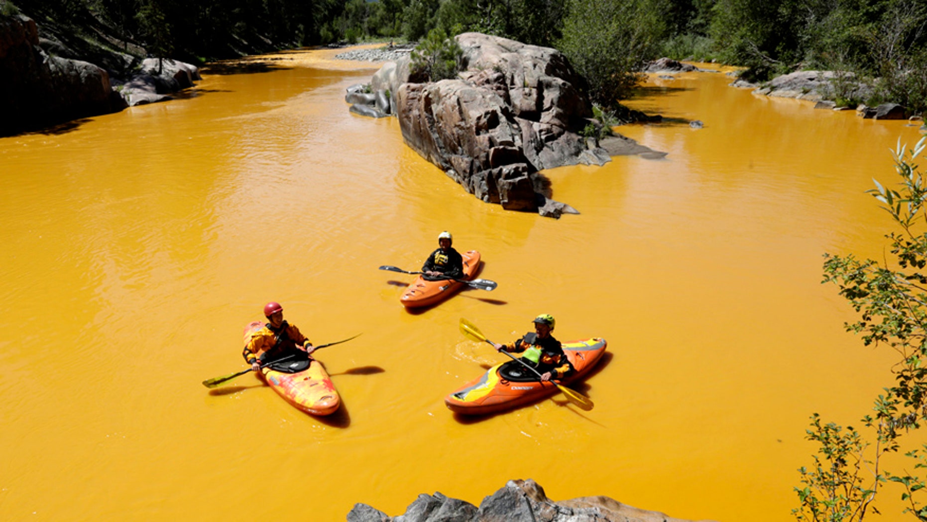 Aug. 6, 2015: People kayak in the Animas River near Durango, Colo., in water colored from a mine waste spill.