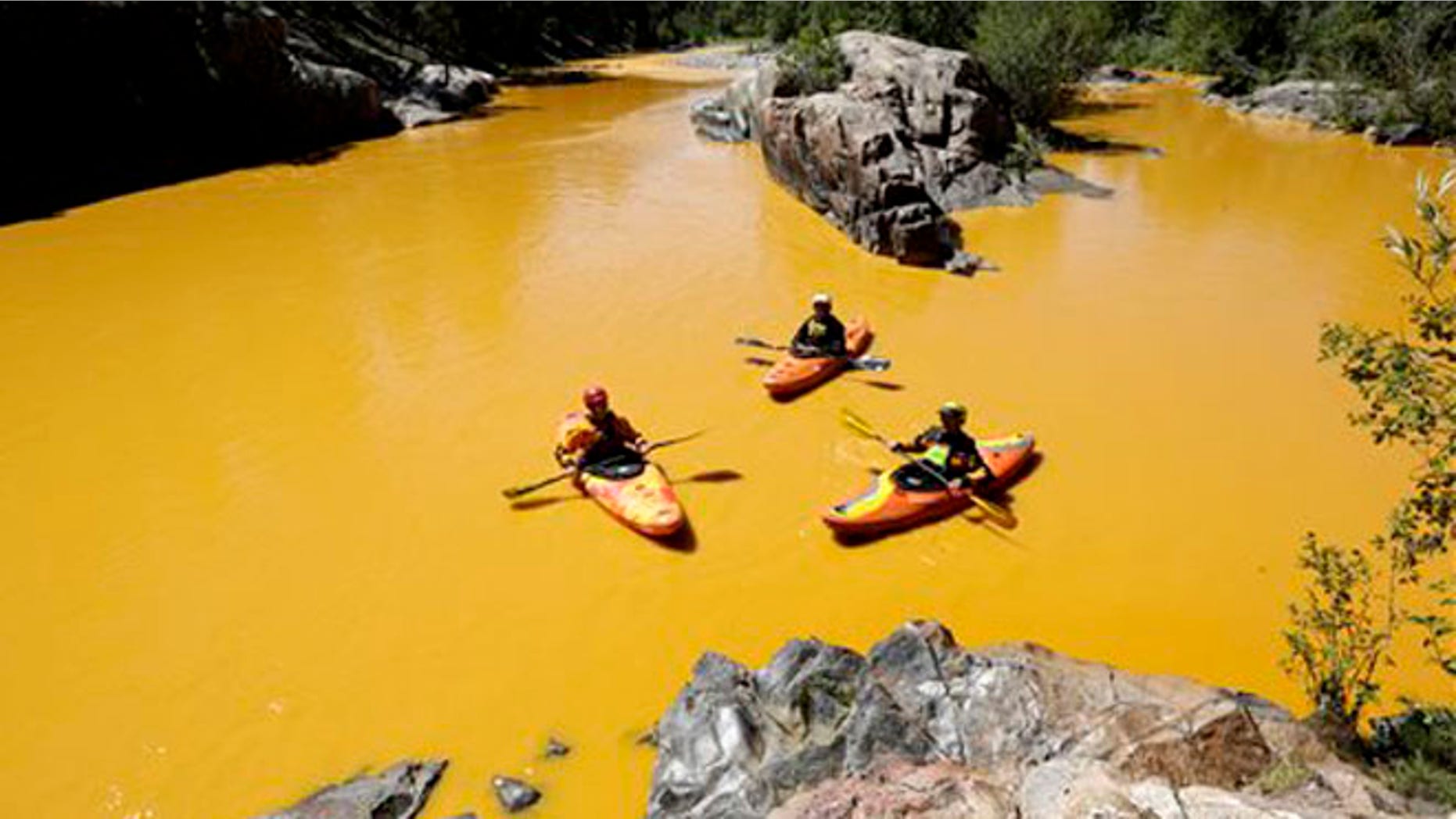 FILE - In this Aug. 6, 2015 file photo, people kayak in the Animas River near Durango, Colo., in water colored from a mine waste spill. The federal government and Colorado have made little progress in remedying damages from the 2015 release of millions of gallons of wastewater from a southern Colorado mine, New Mexico's top prosecutor charged in a pair of scathing letters sent to officials on Friday, May 20, 2016.(Jerry McBride/The Durango Herald via AP, File) MANDATORY CREDIT