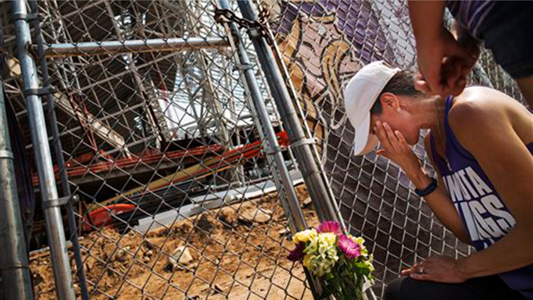 Aug. 25, 2015: Angela Strong and daughter Kyra,11, of St. Paul, Minn. leave a bouquet of flowers and say prayers for the construction workers in Minneapolis.