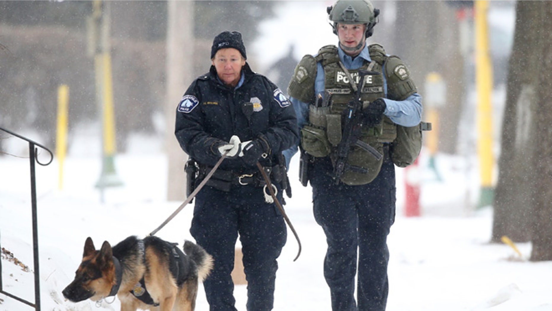 Feb. 21, 2015: An officer searches with a dog accompanied by a SWAT team member after a Minneapolis police officer was shot in Minneapolis. (AP)