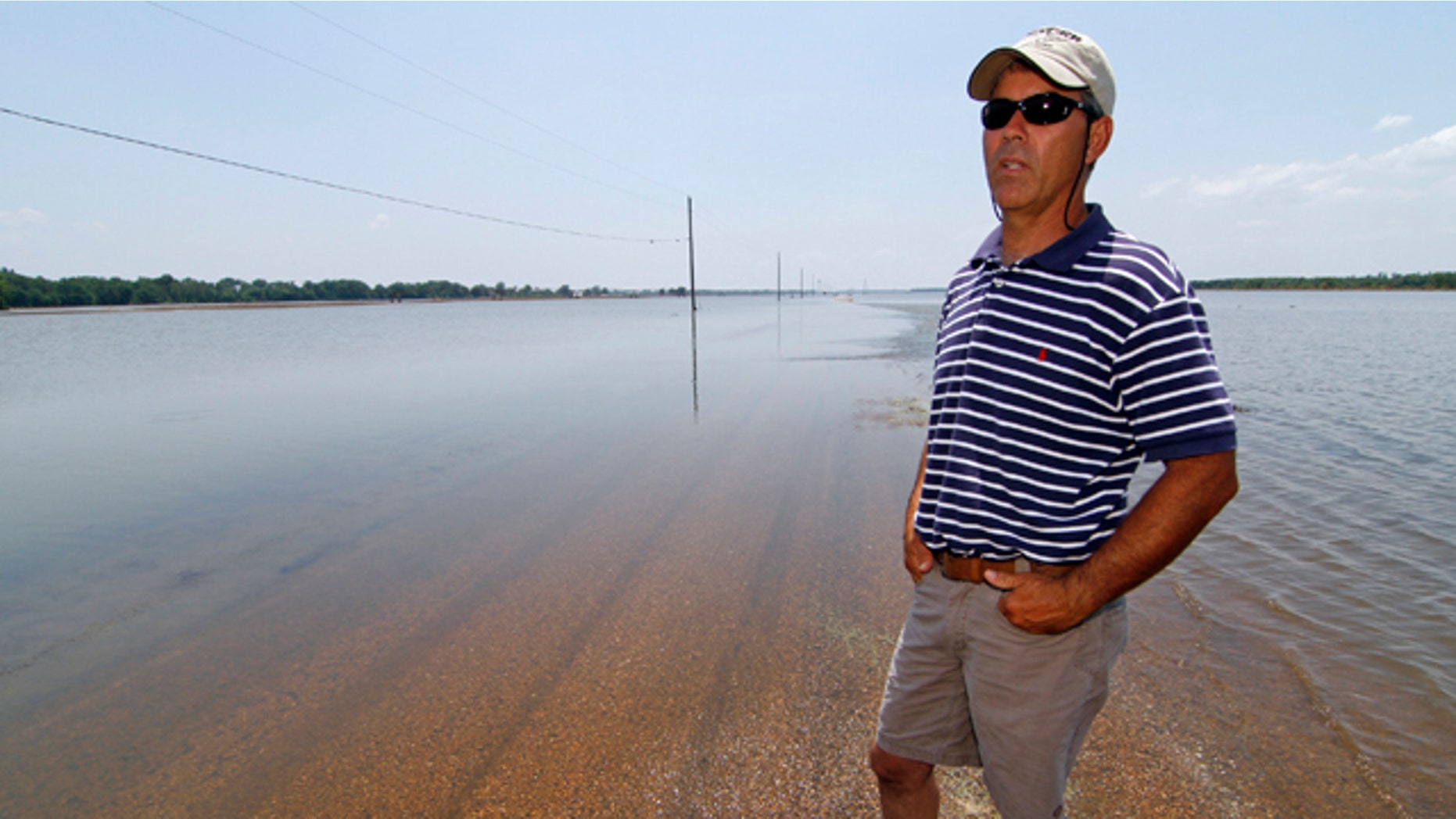 June 1: Farmer Brett Robinson stands on the road between his flooded farm fields near his house outside of Yazoo City, Miss.