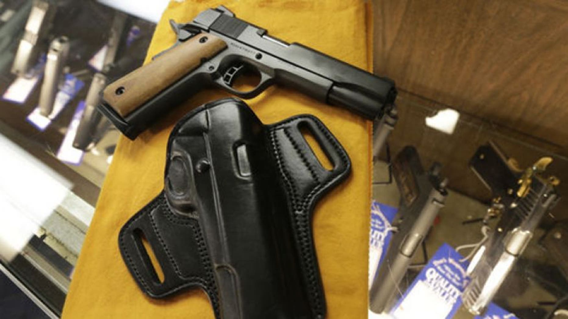 Aug. 24, 2013: A semi-automatic handgun and a holster are displayed at a North Little Rock, Ark., gun shop.