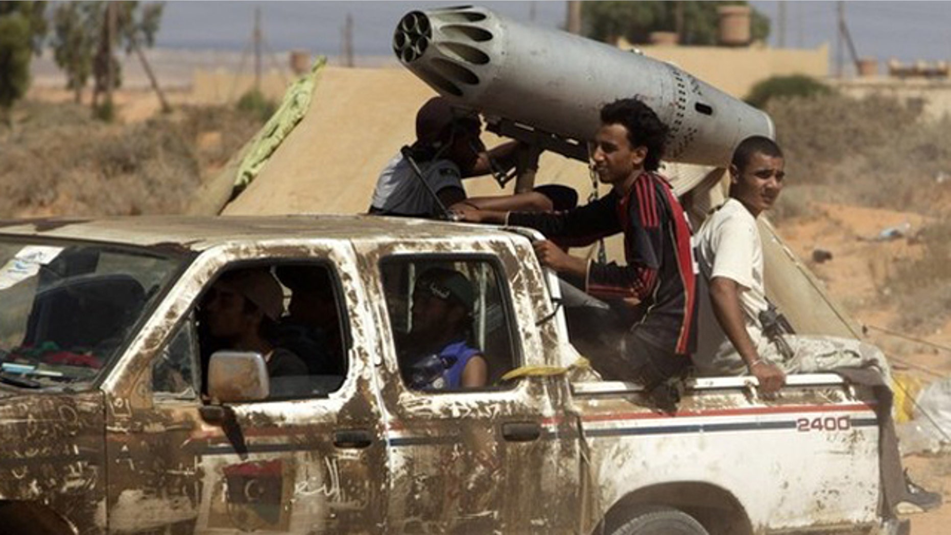 Sept. 14: Anti-Qaddafi fighters drive with a converted missile launcher from an aircraft near a check point.