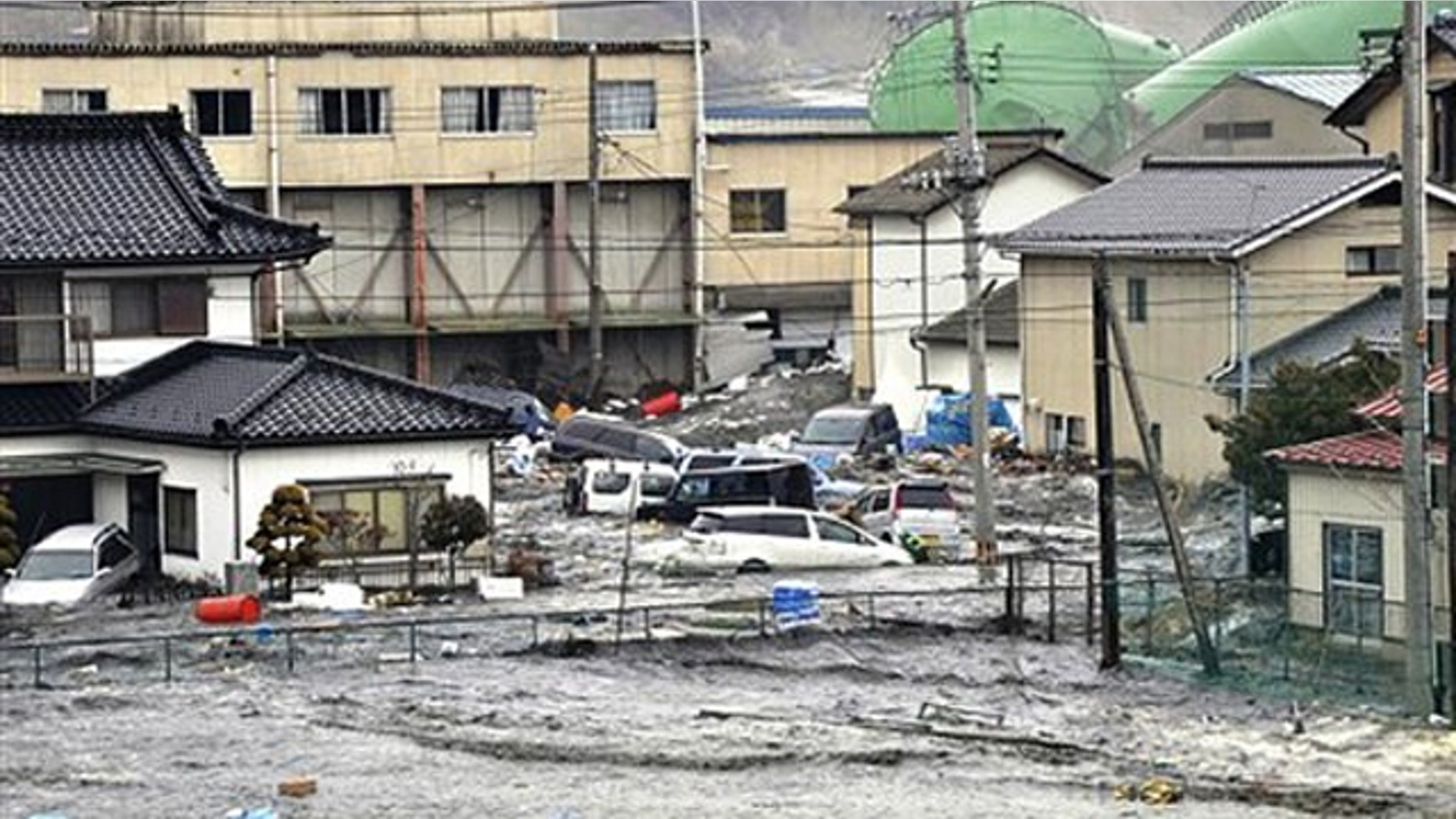 An earthquake-triggered tsunami washes away a warehouse and vehicles in Kesennuma, Miyagi in Japan March 11.